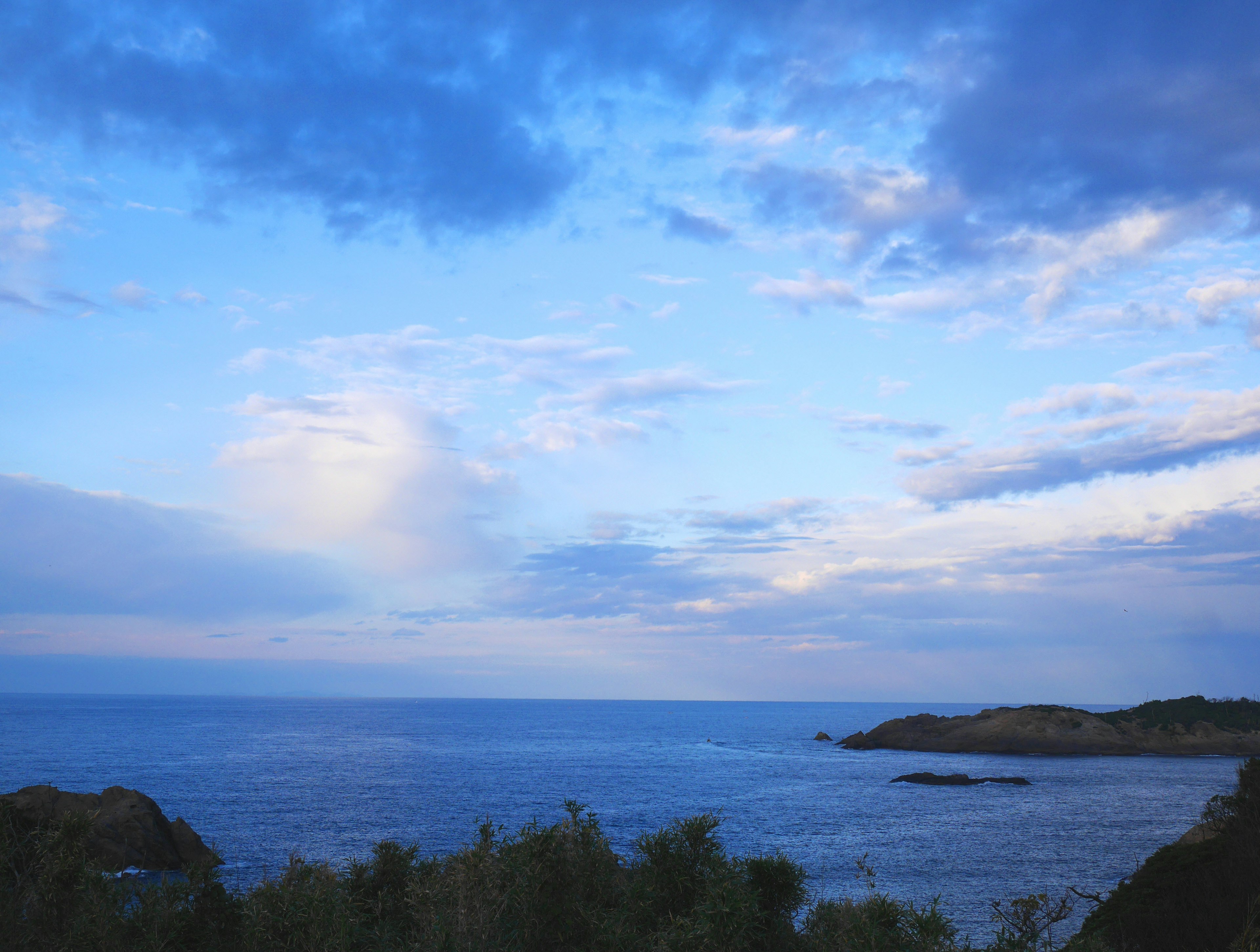 Scenic view of blue sky and ocean with varying clouds