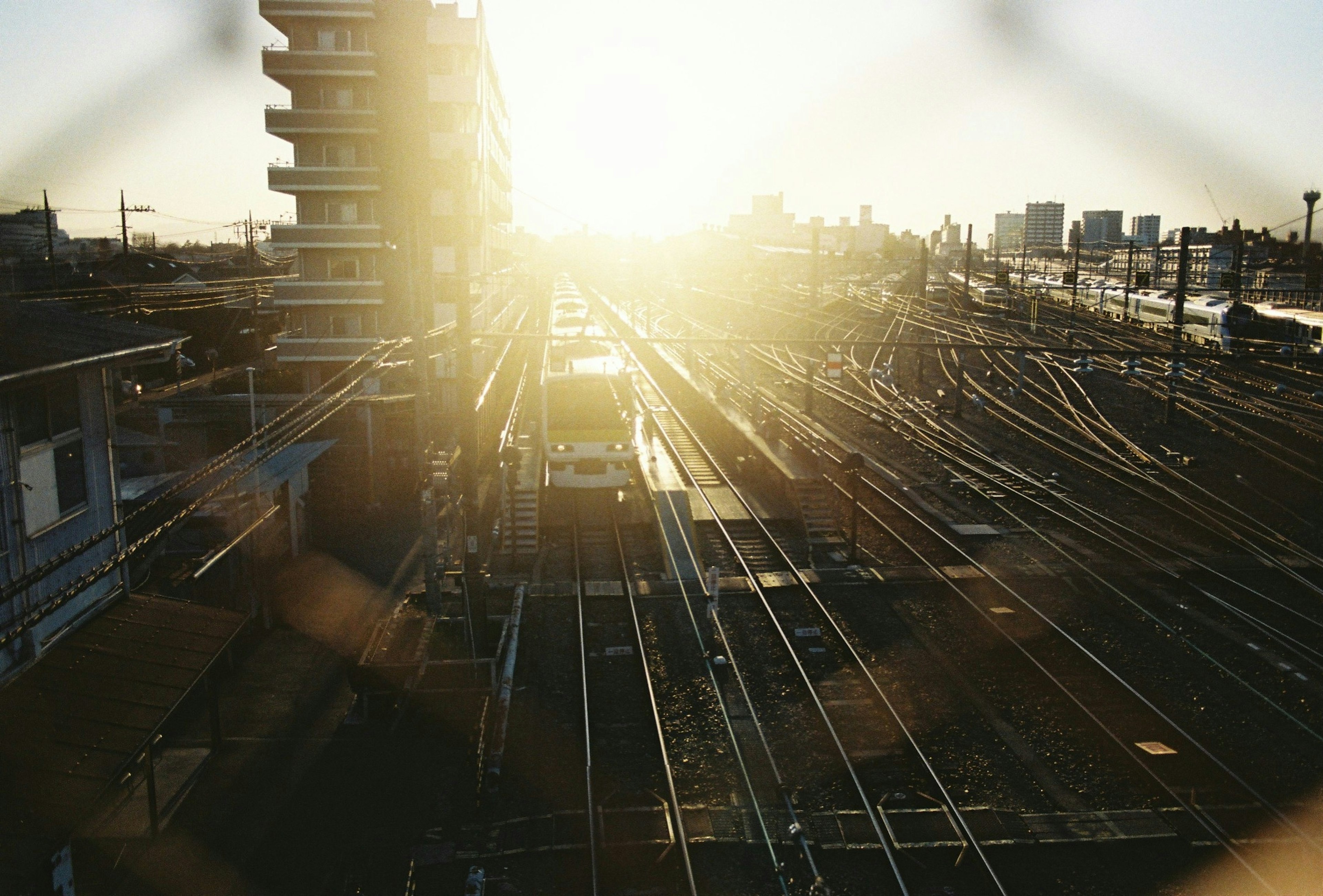 Cityscape with railway tracks illuminated by sunset