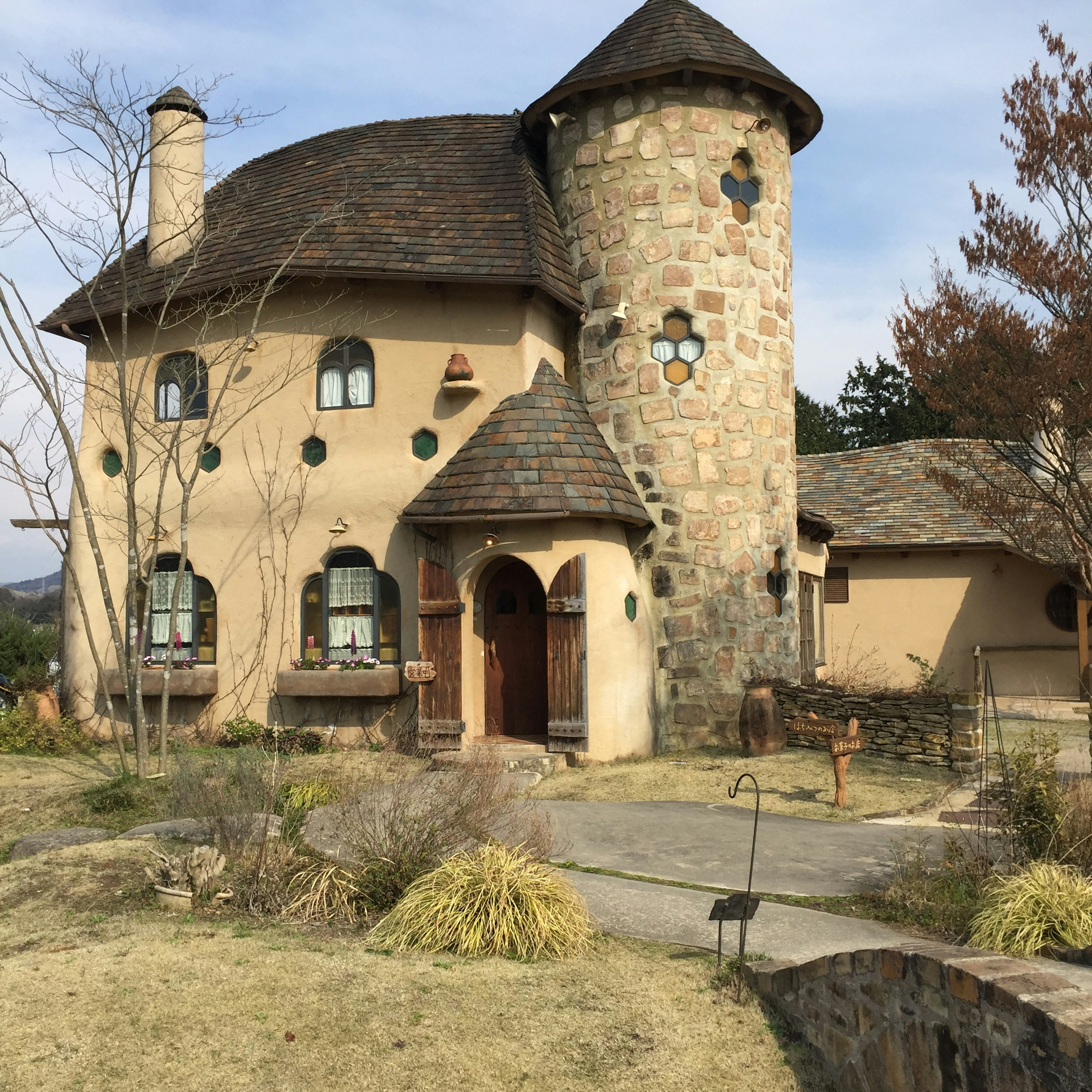 Casa de piedra de estilo de cuento de hadas con torre y ventanas únicas