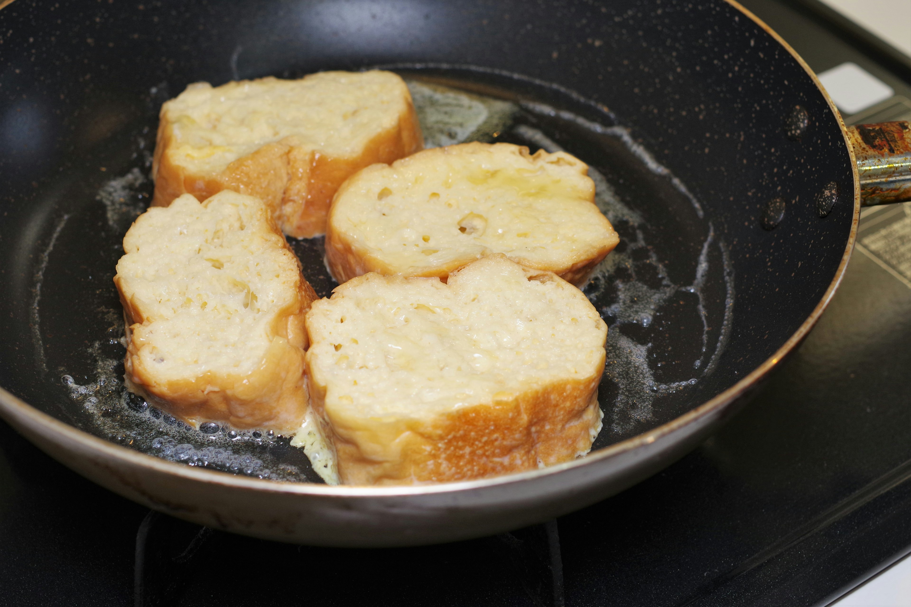 Slices of bread frying in a pan