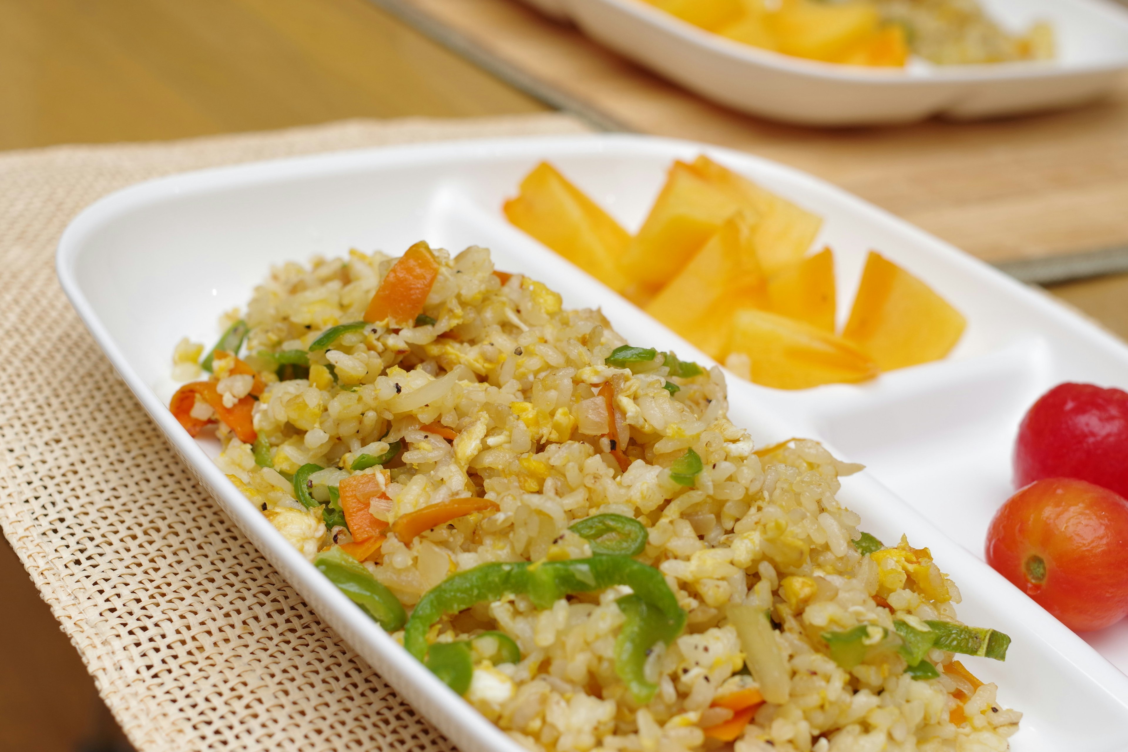 Delicious fried rice with colorful vegetables and fruit slices