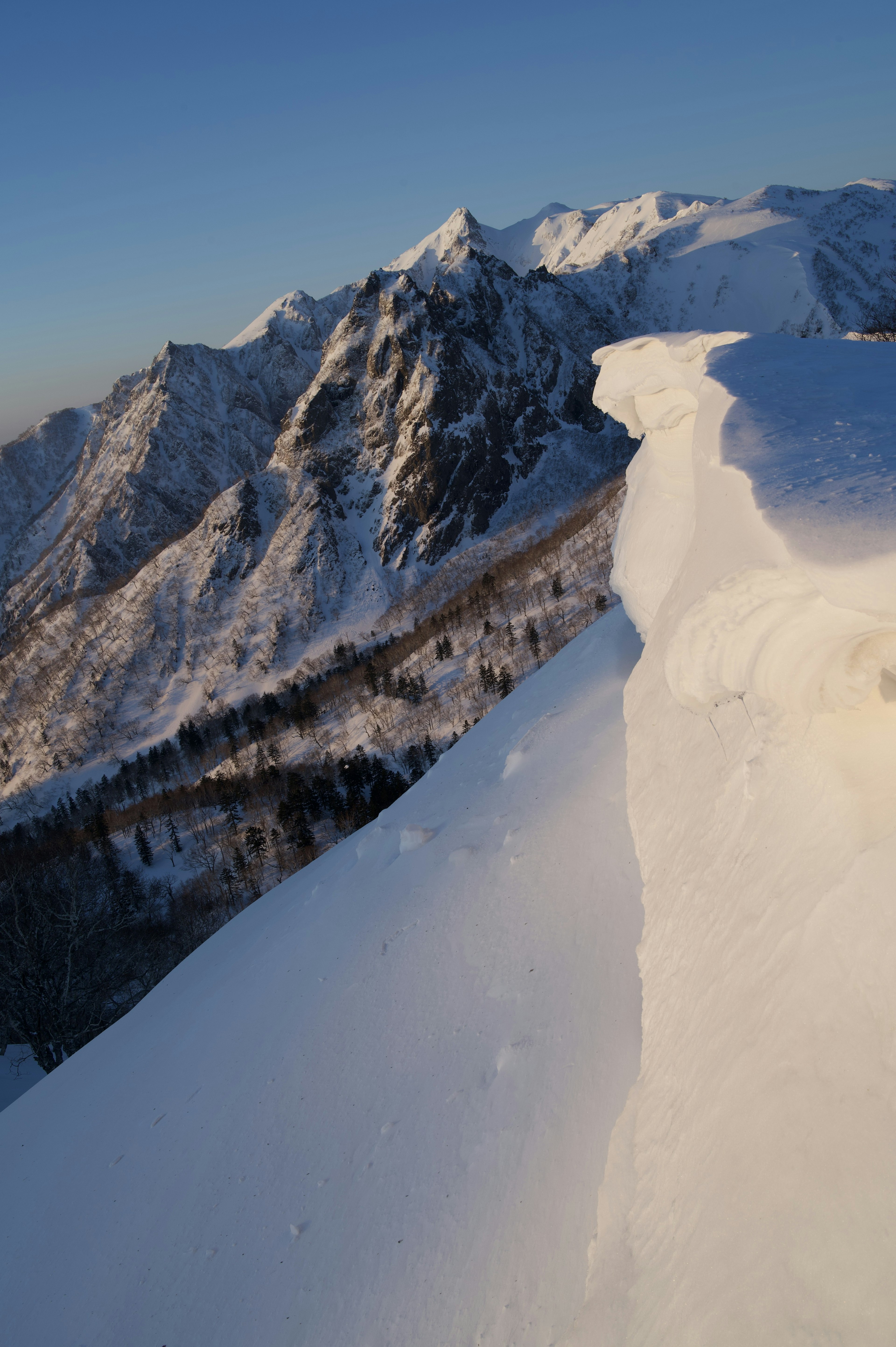 Snow-covered mountain landscape with clear blue sky