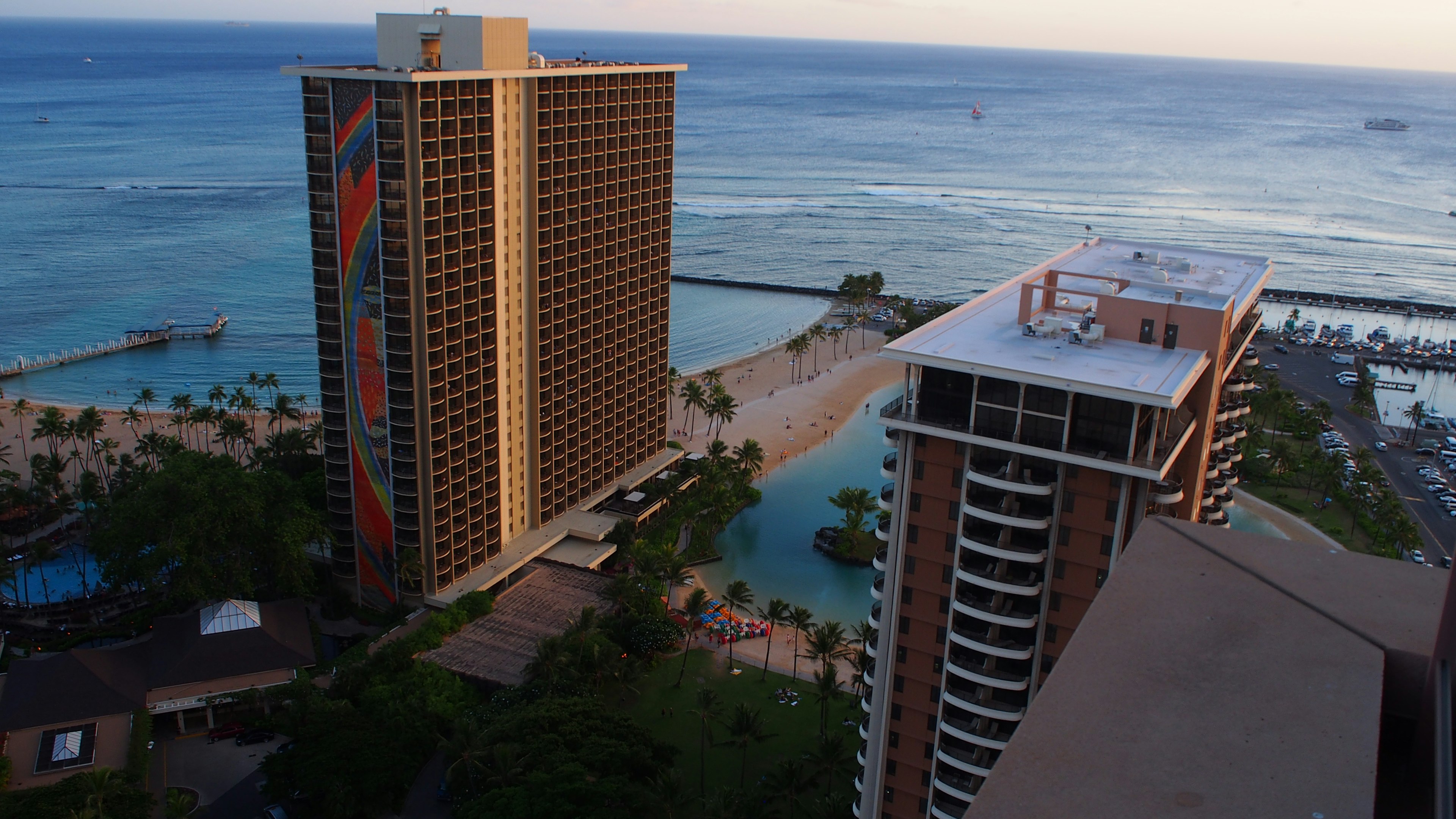 Aerial view of high-rise buildings overlooking a beautiful ocean in a Hawaiian resort area