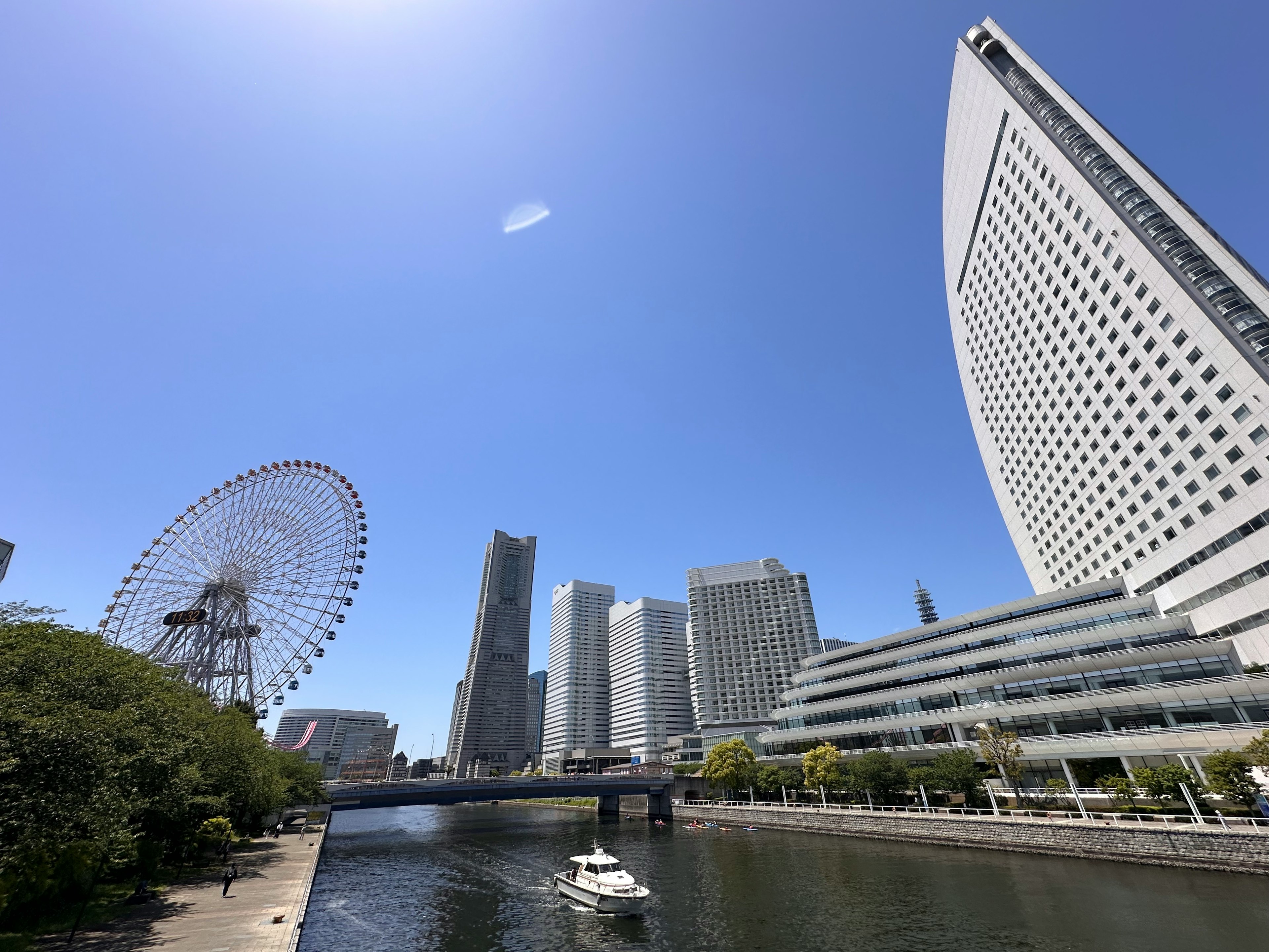 Garis langit Yokohama dengan roda raksasa dan bangunan modern di bawah langit biru yang cerah