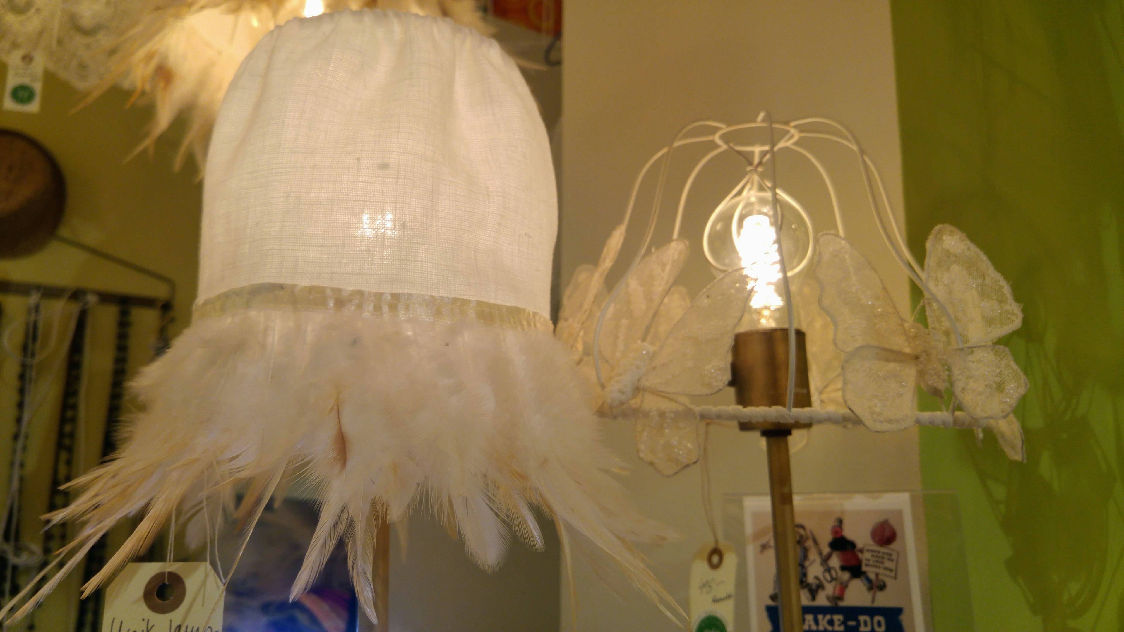 Unique lamp with a white feather shade and a simple lamp stand