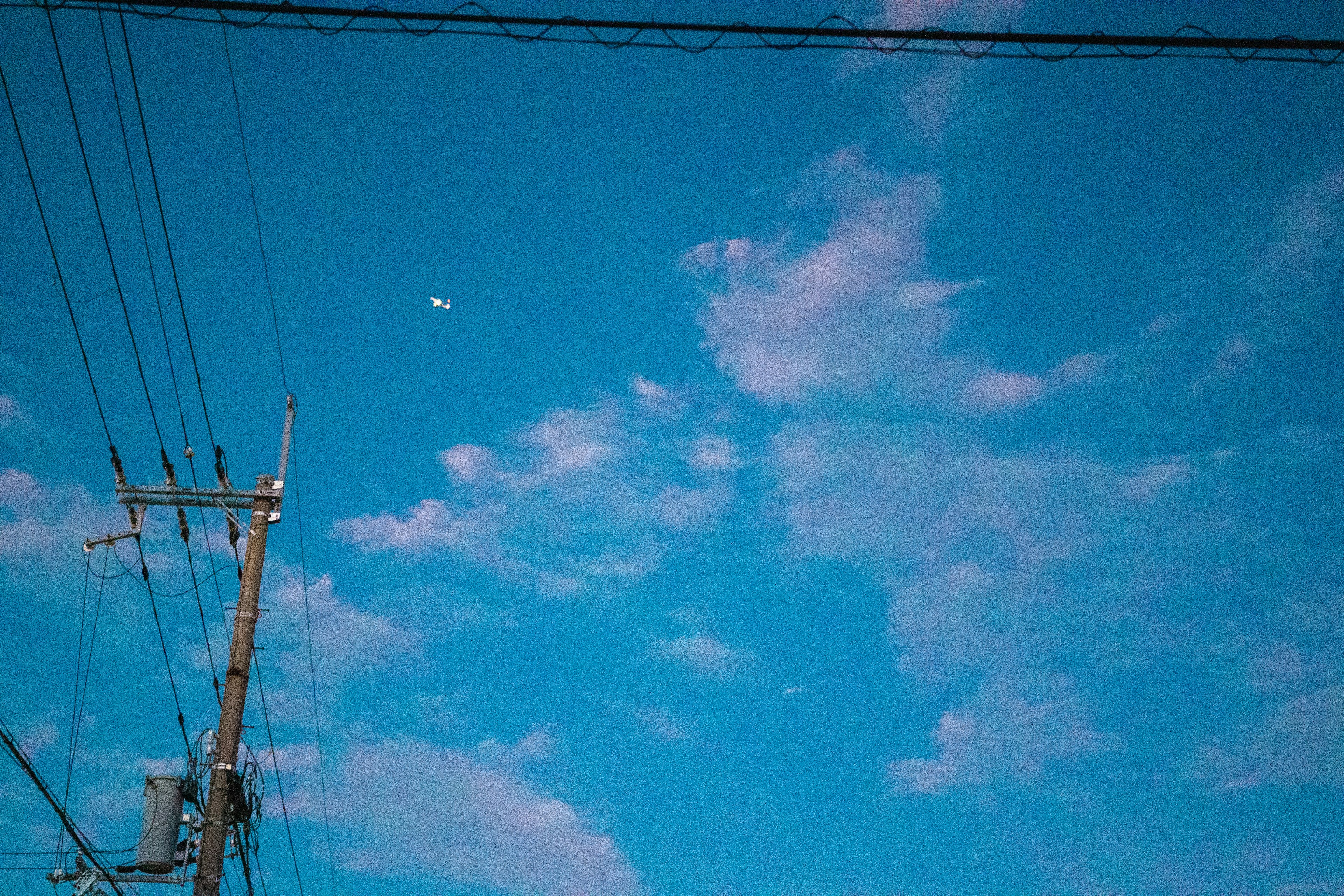 Ciel bleu avec des nuages blancs et des lignes électriques