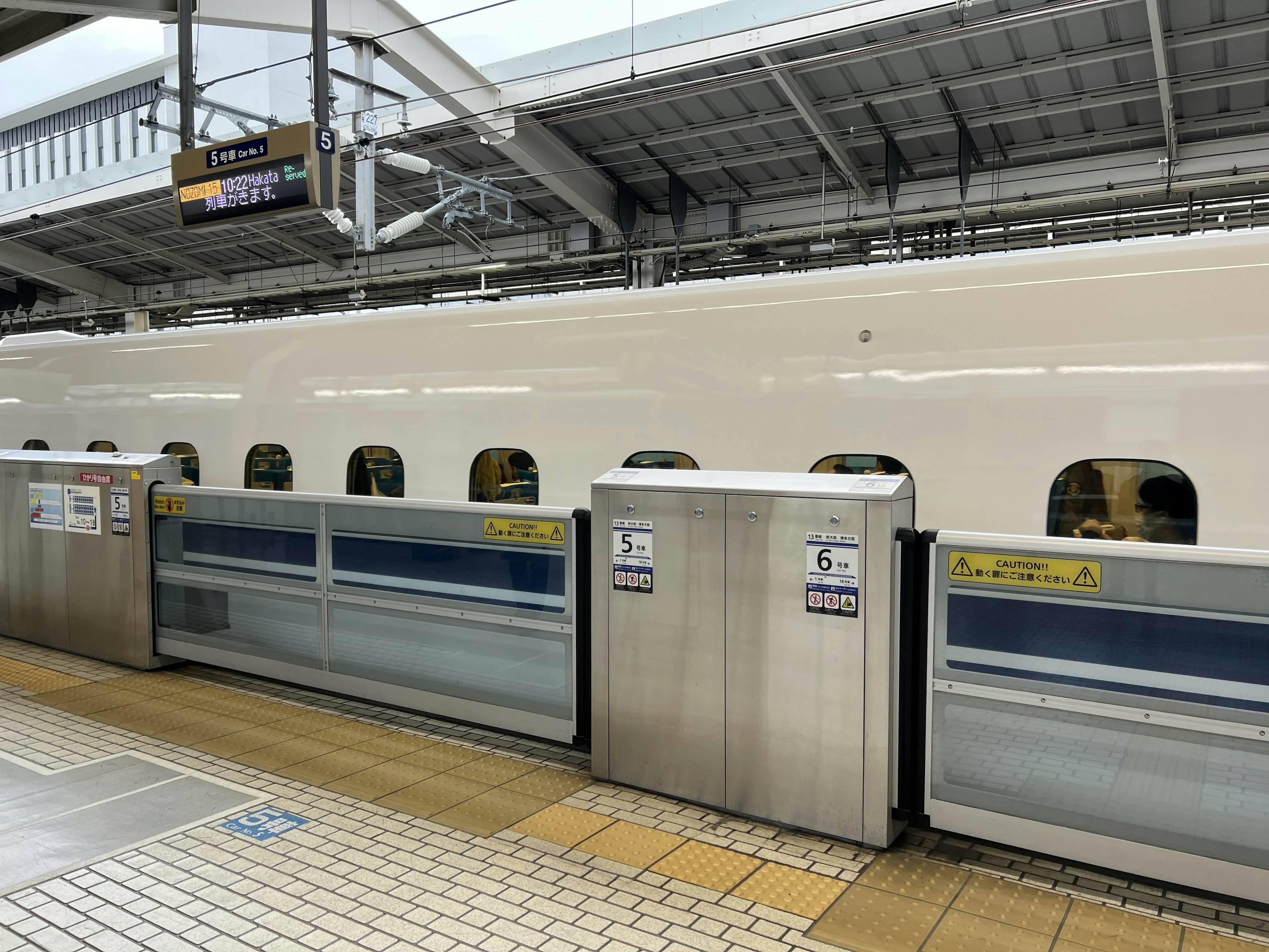 Shinkansen train at a station showing the platform and train design