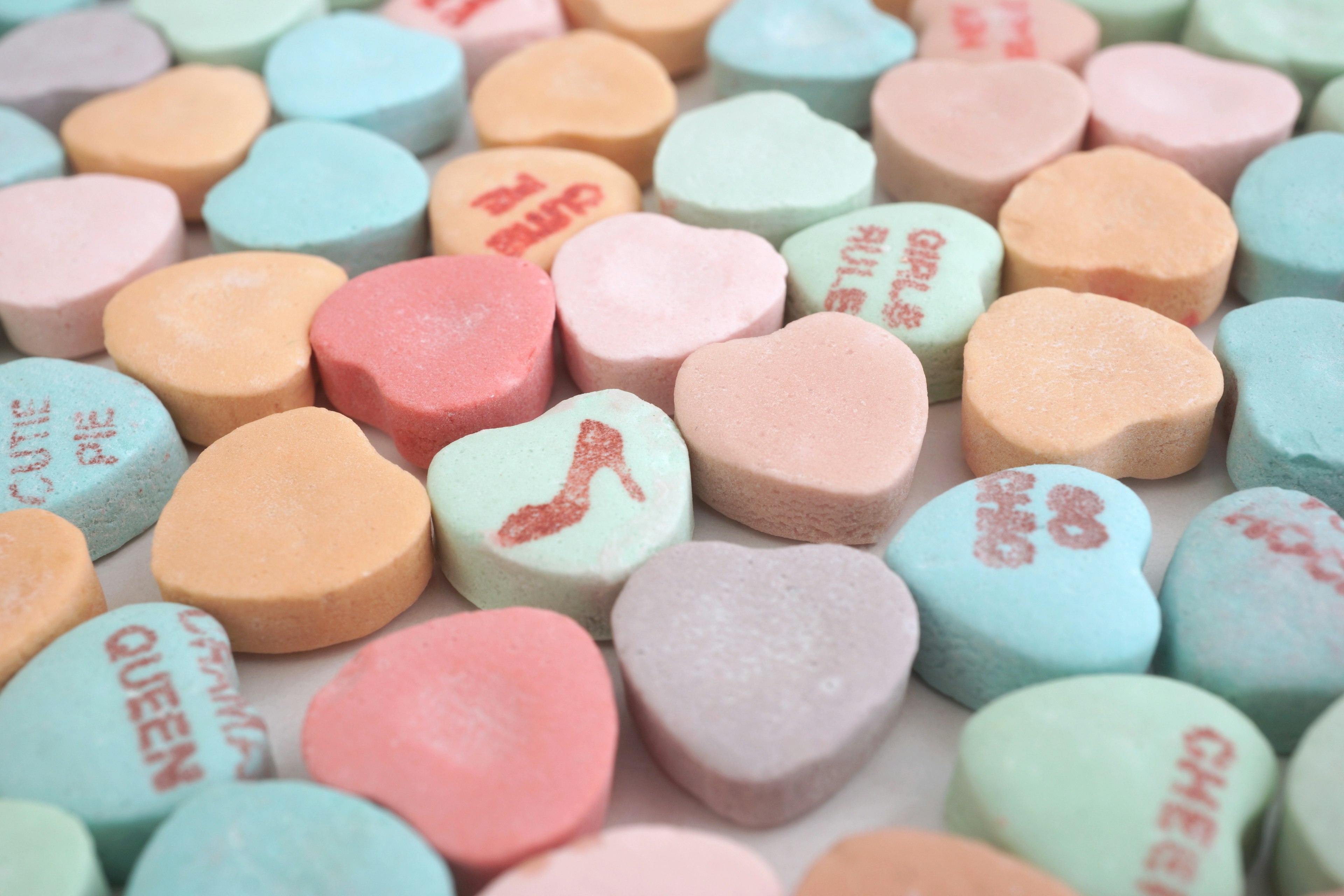 Colorful heart-shaped candies scattered on a surface