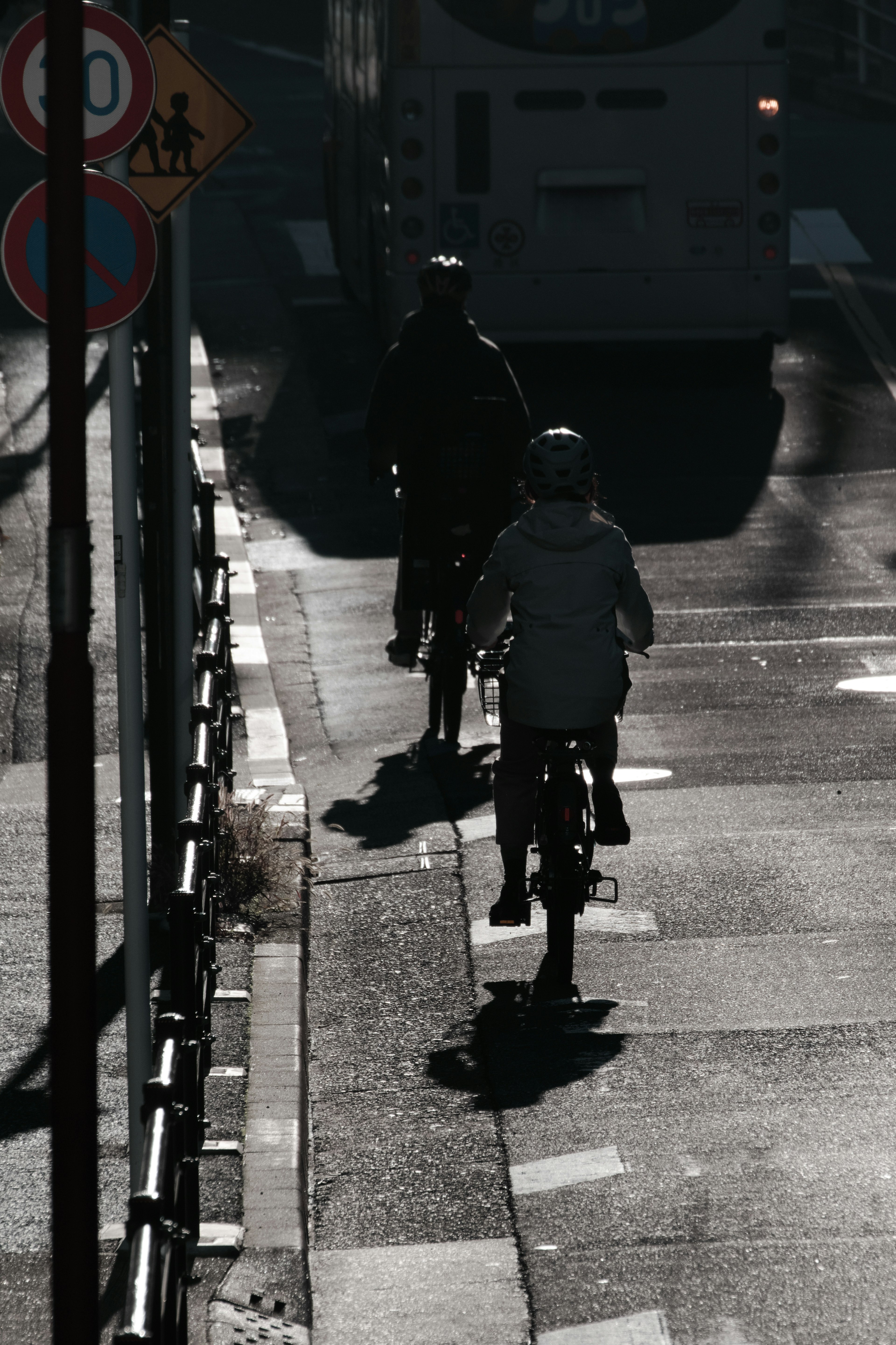 Due ciclisti che pedalano su una strada ombrosa