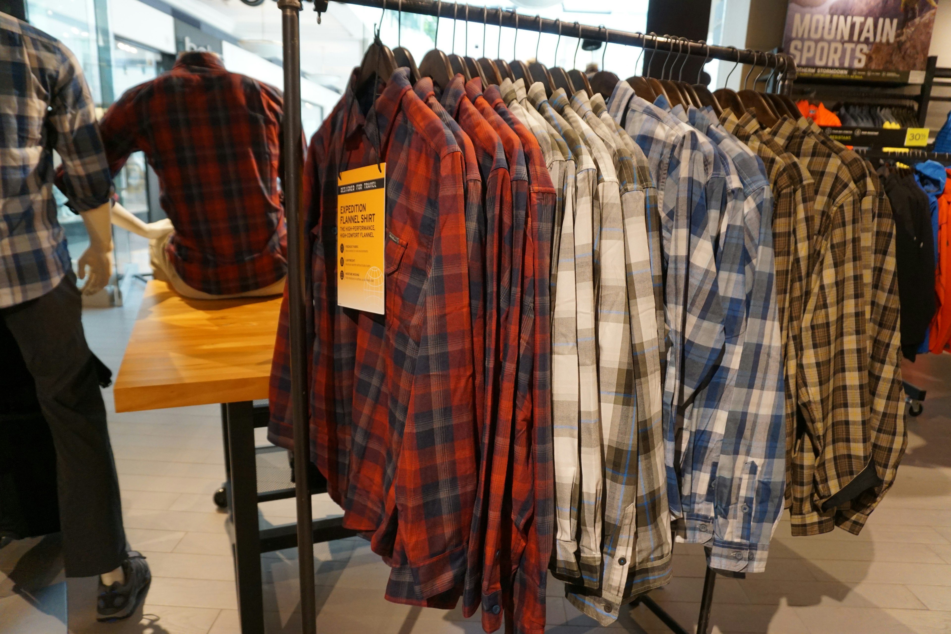 Display of plaid shirts hanging in a retail store