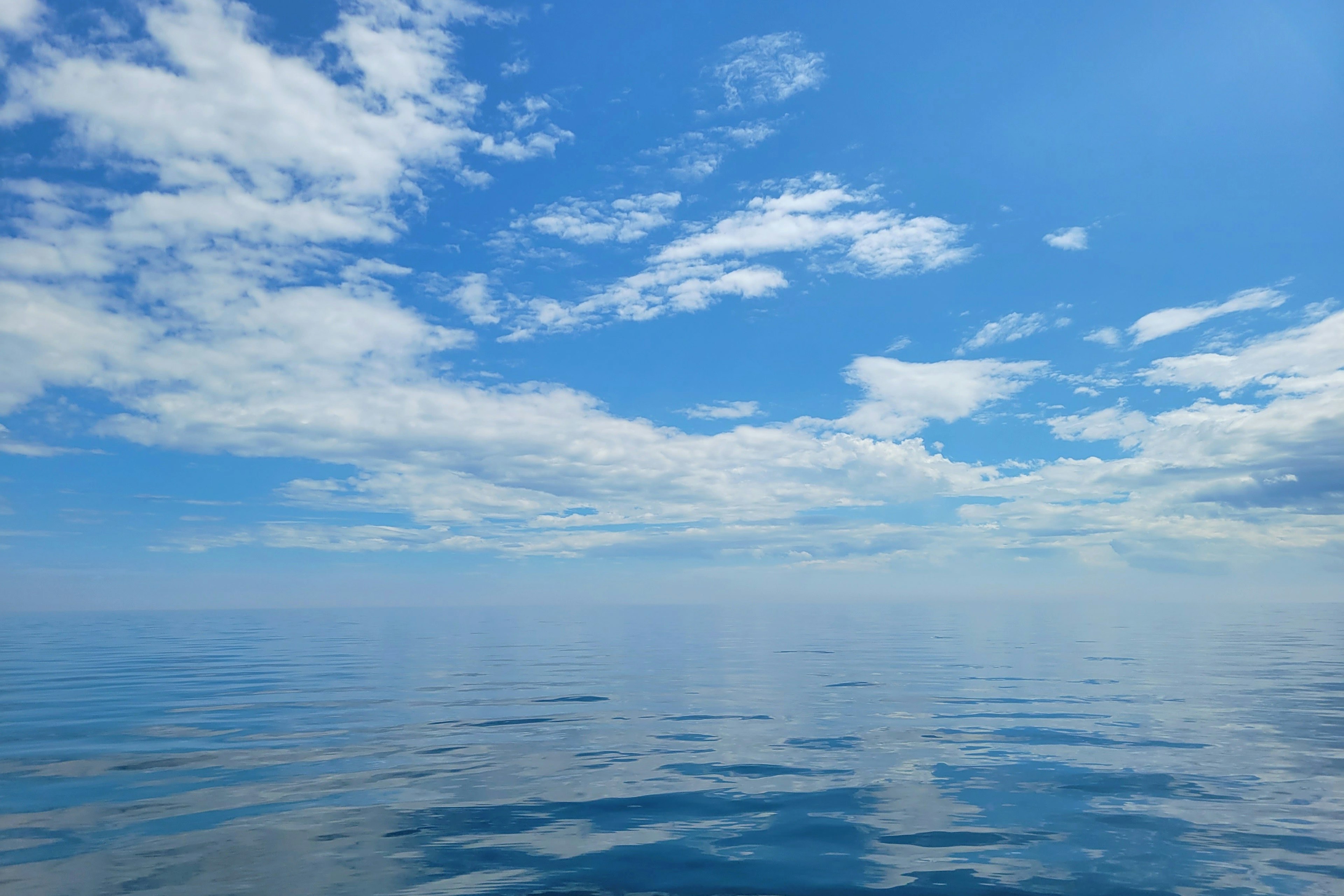 Ruhige Ozeansicht mit blauem Himmel und Wolken