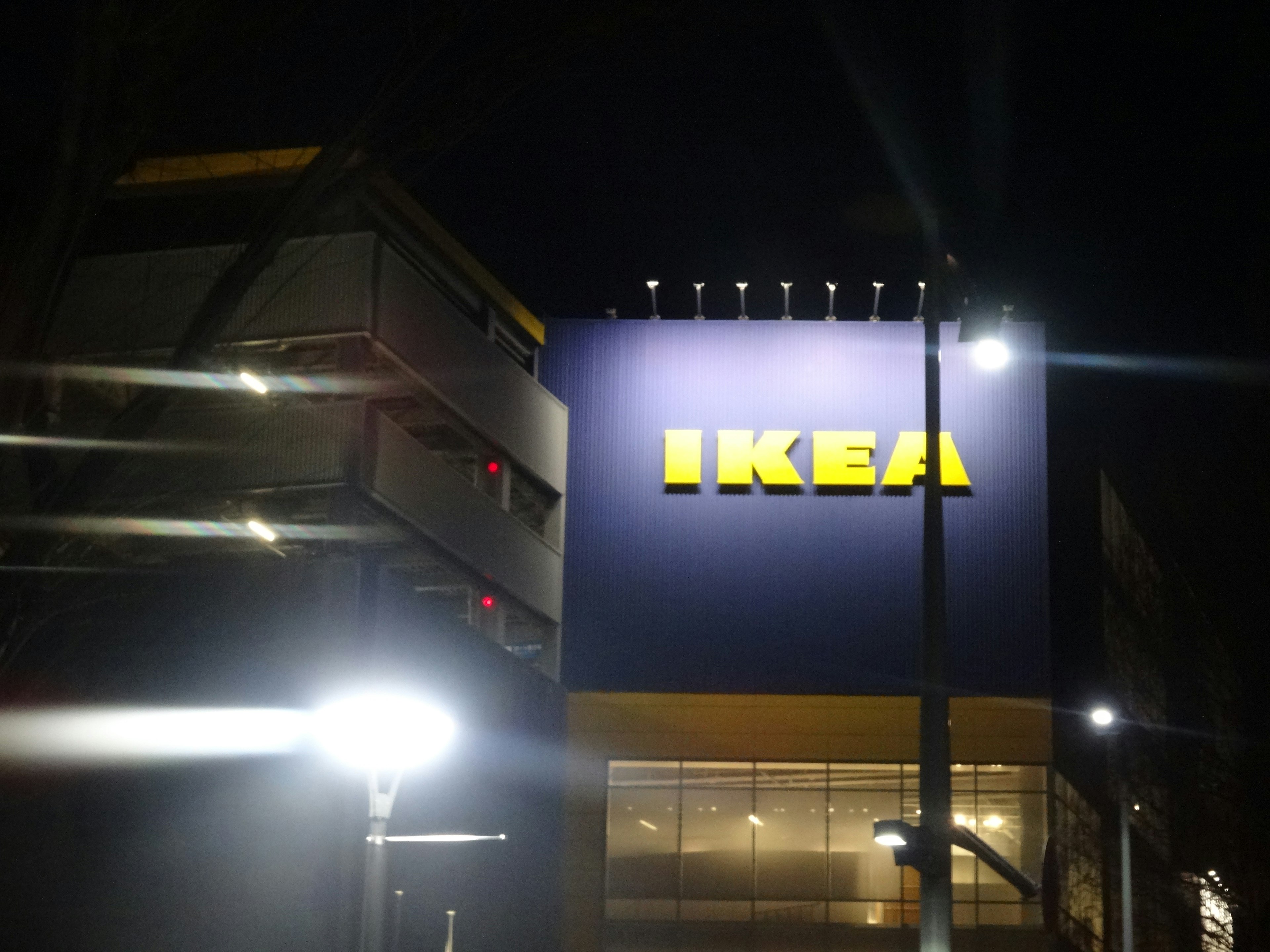 IKEA sign illuminated at night with surrounding lights