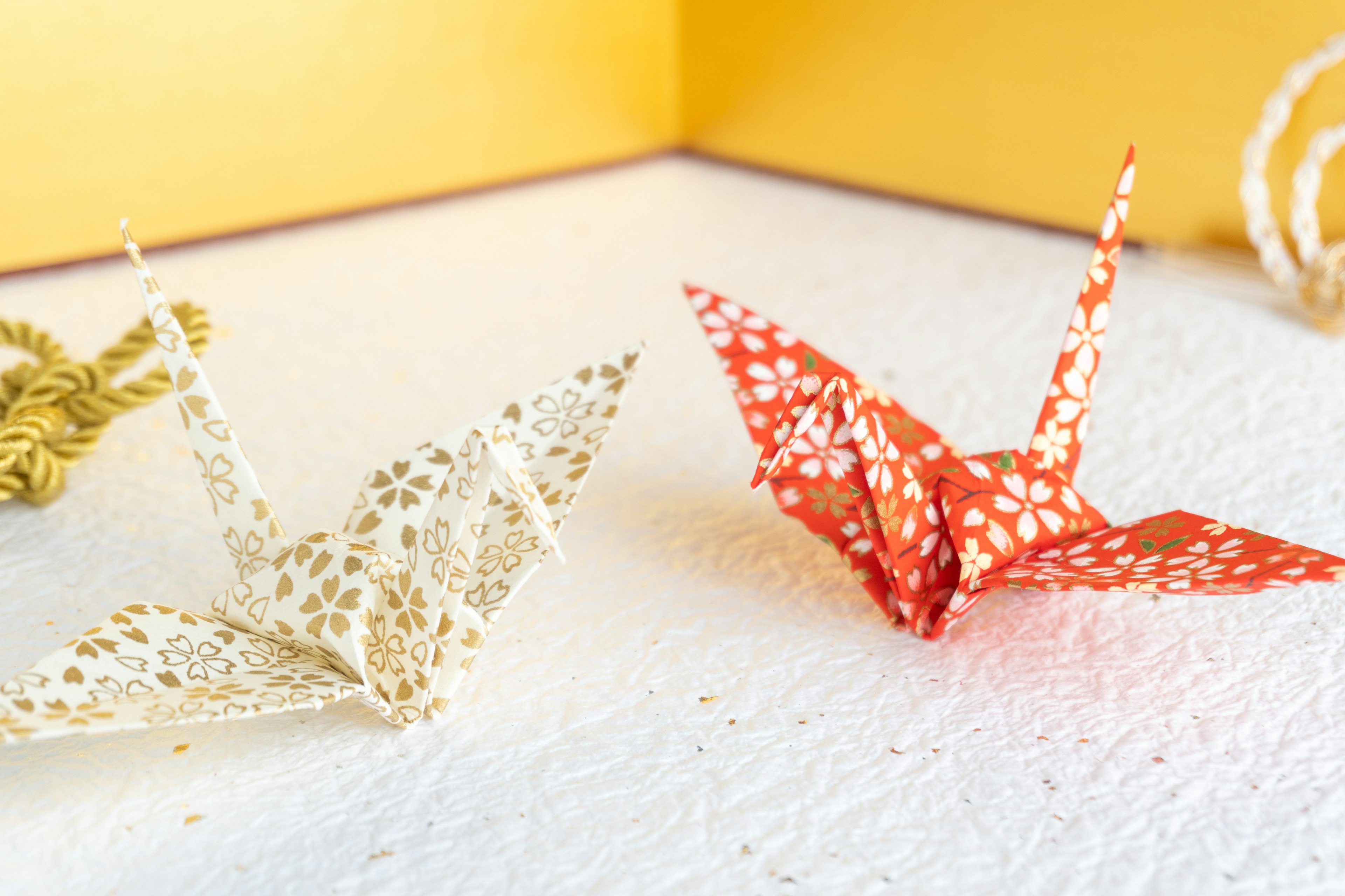 Cranes origami trắng và đỏ đặt trên nền vàng