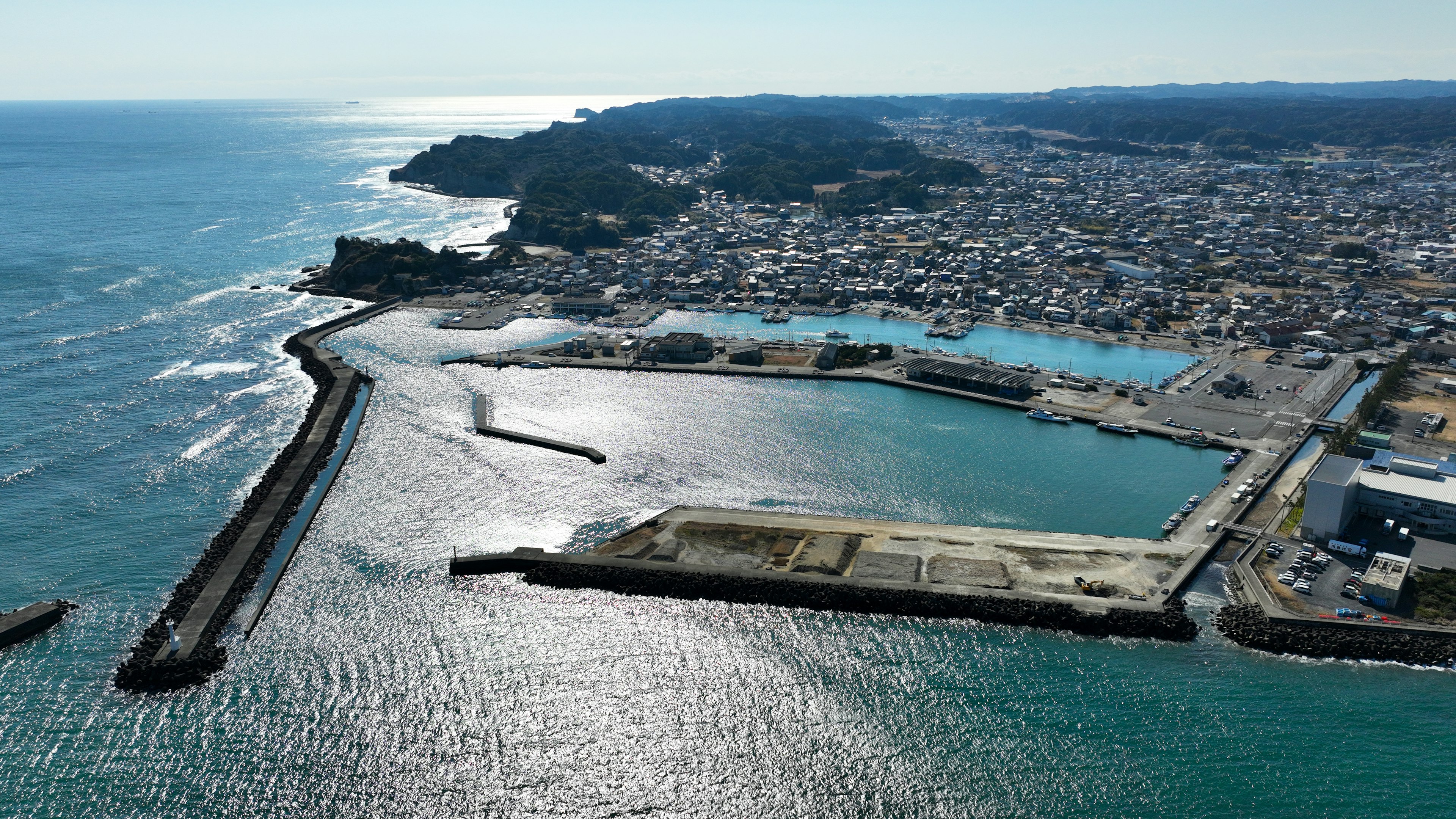 Aerial view of a coastal town featuring a harbor and blue ocean