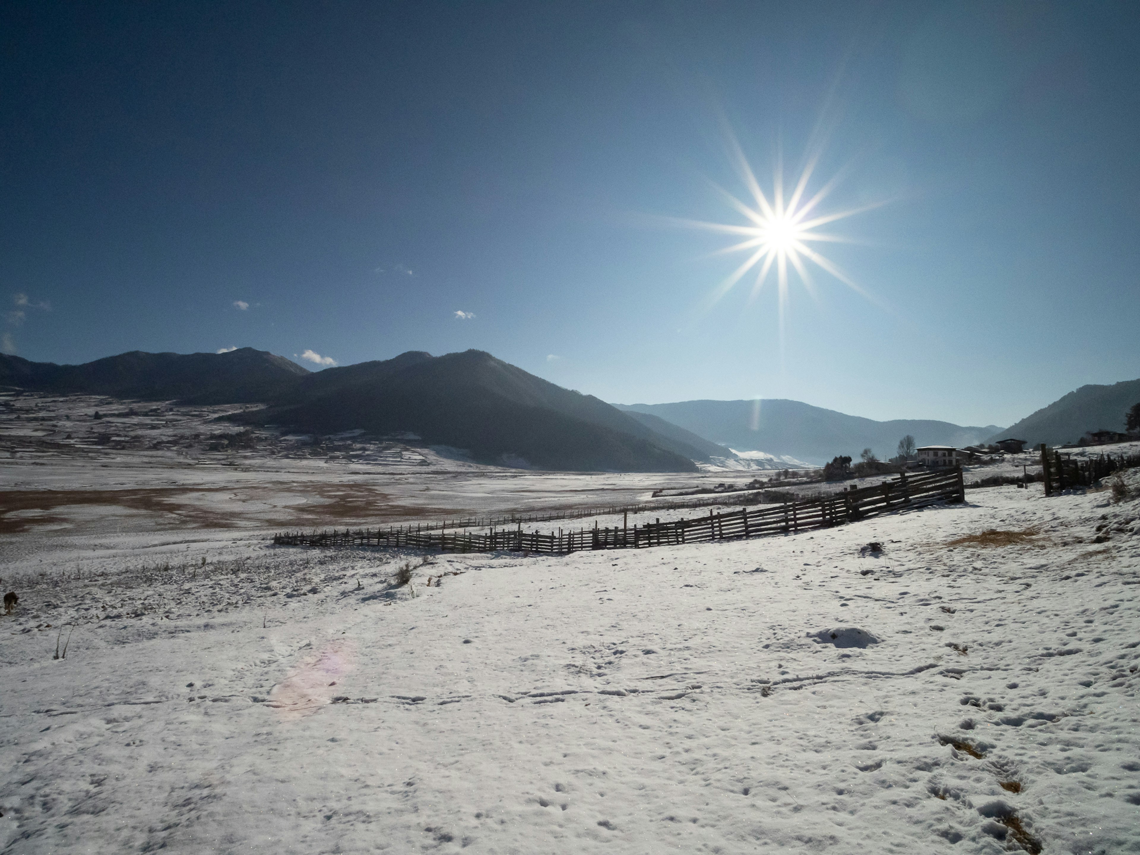 雪に覆われた広大な風景と太陽が輝く山々