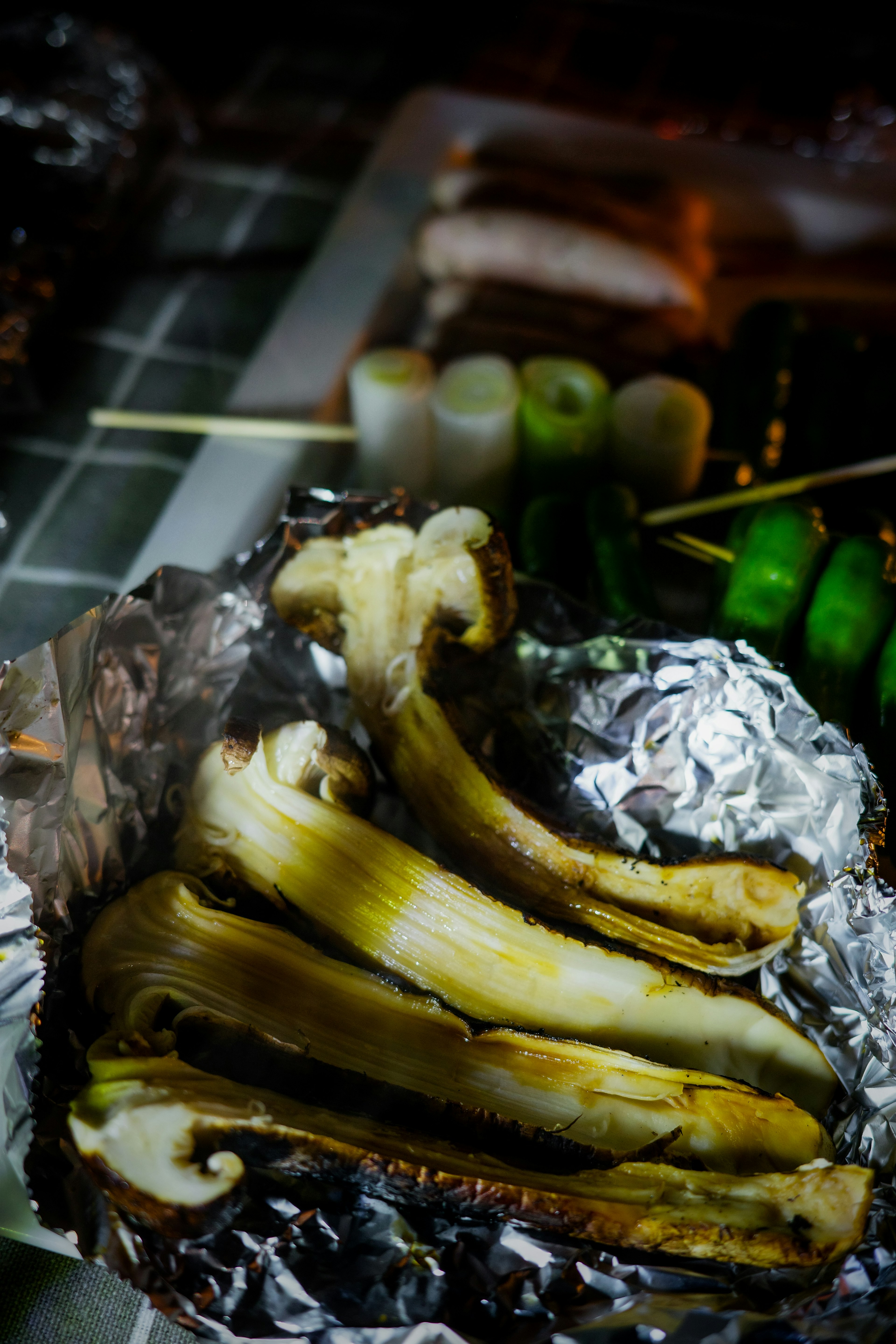 Grilled food resembling bananas wrapped in aluminum foil