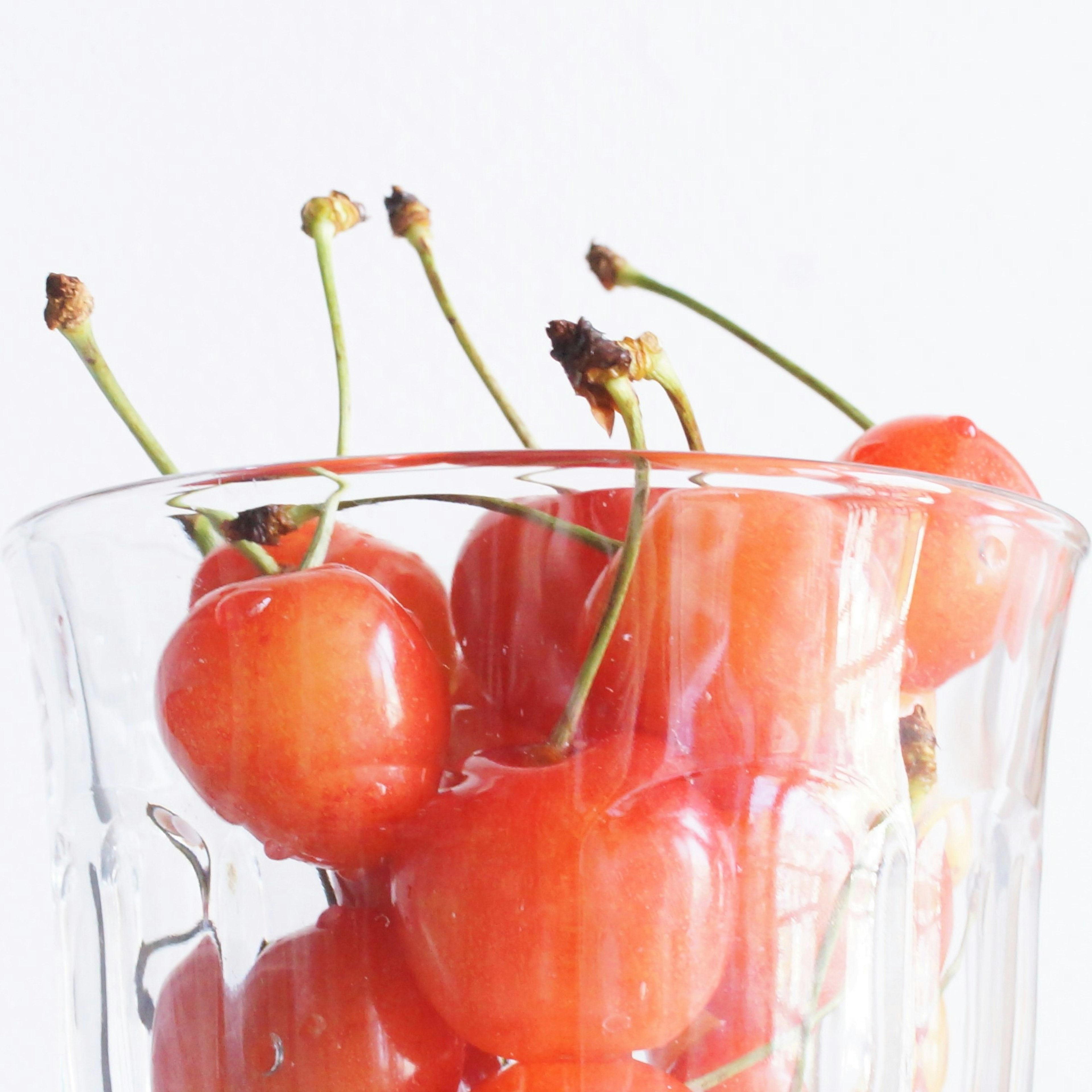 Cerises rouges dans un verre transparent