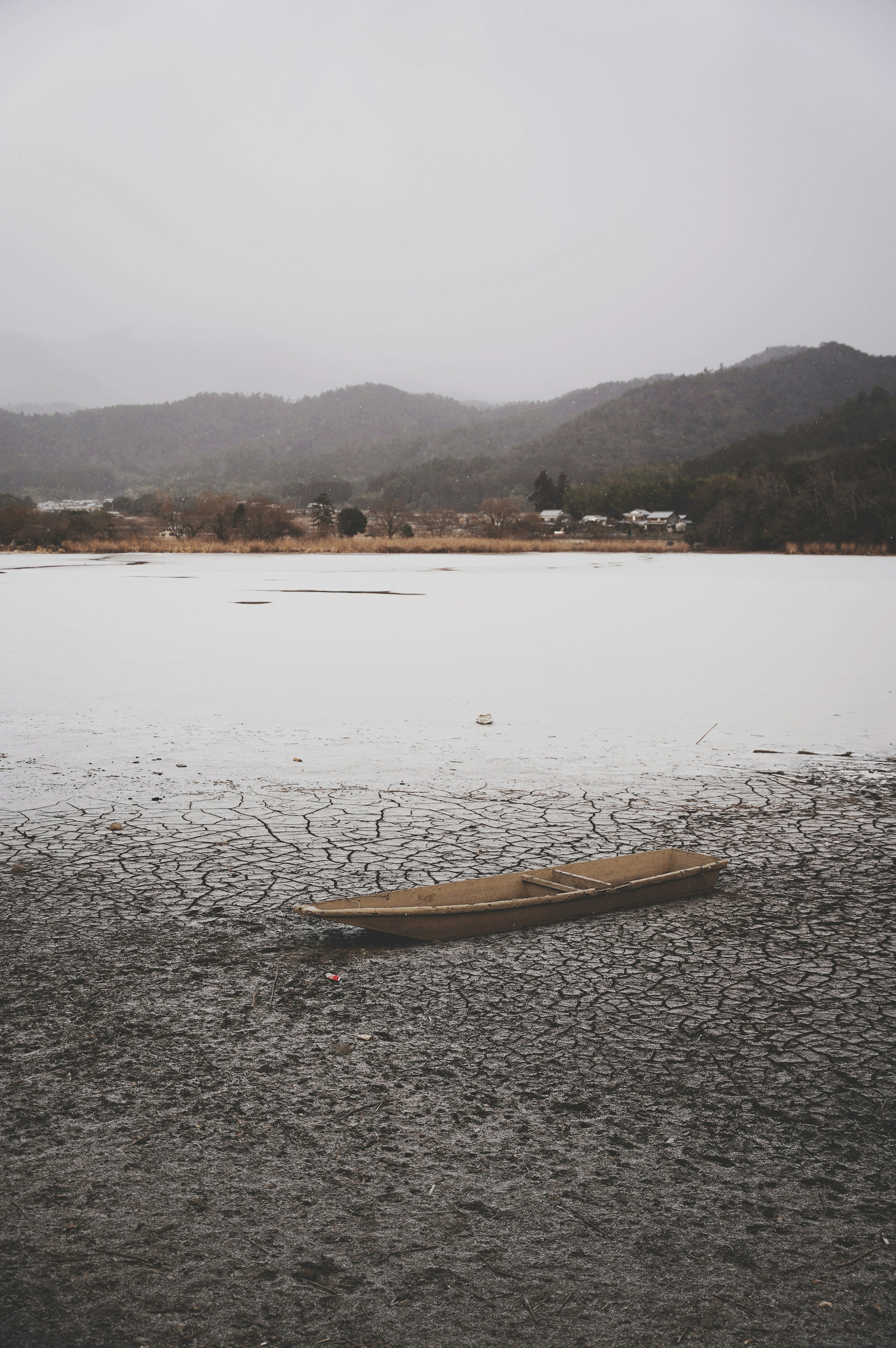 A small boat floating on a calm lake with surrounding mountains