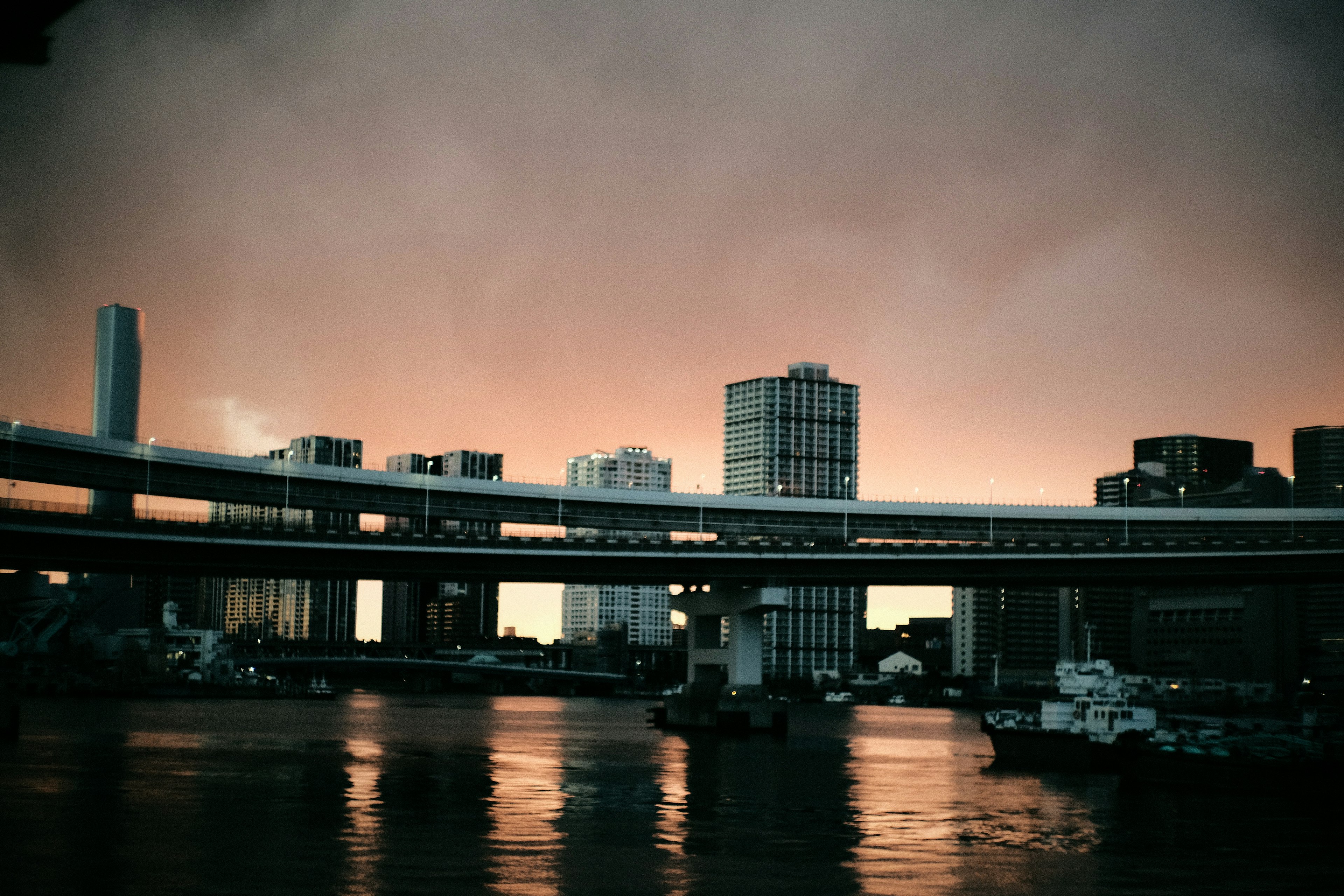 City skyline with buildings and highway under a sunset sky