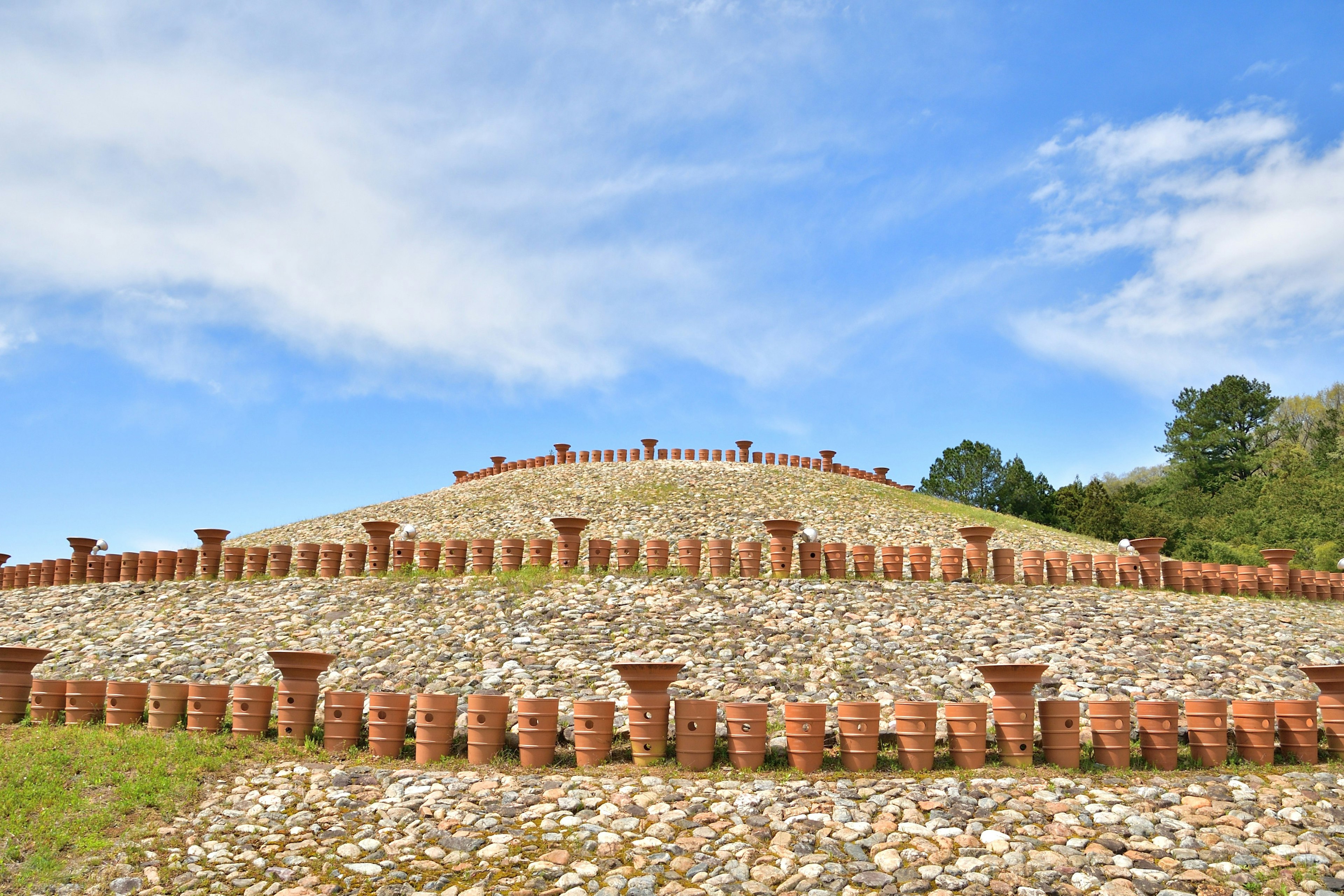 Paysage avec une structure circulaire en briques rouges et un ciel bleu