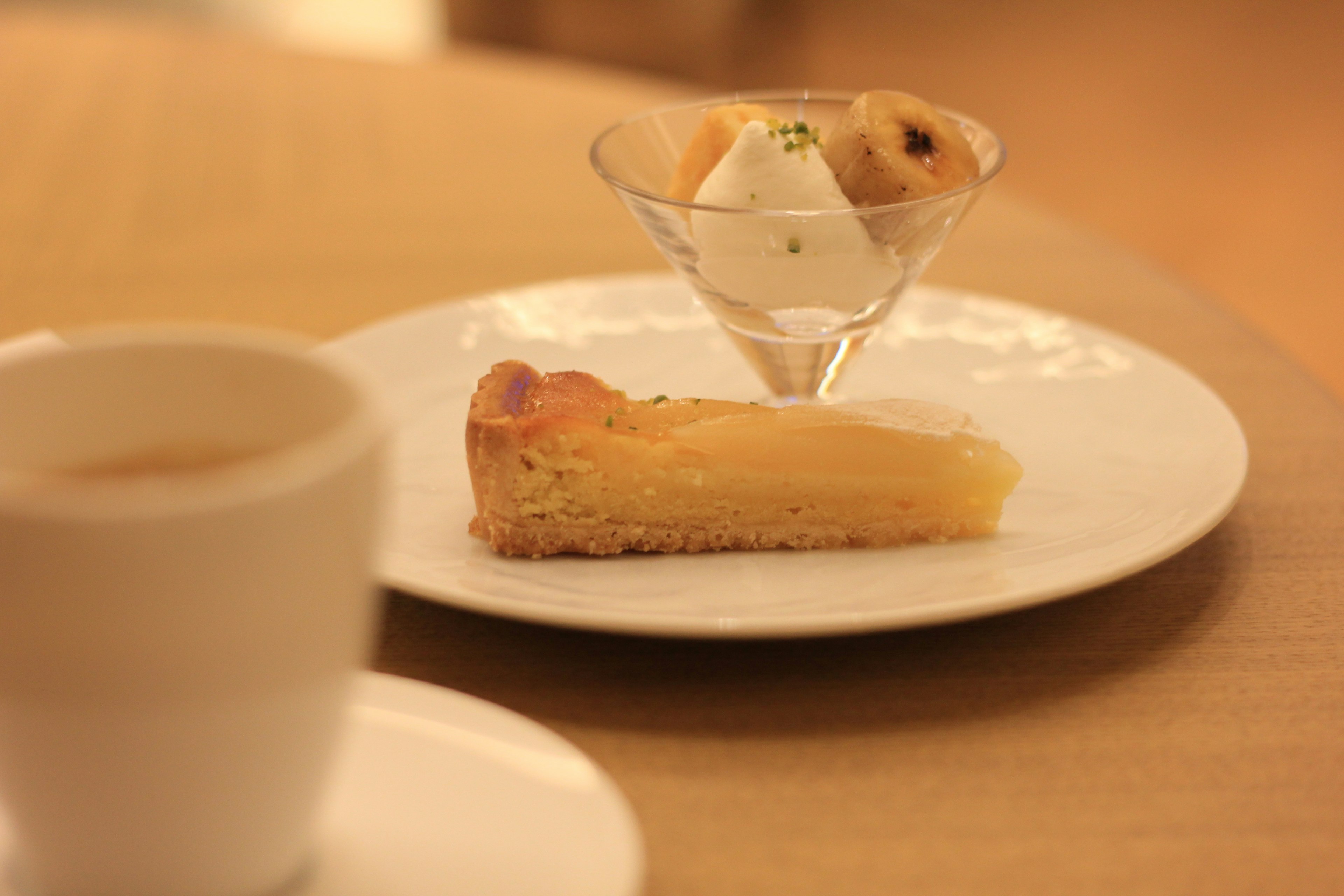 Ein Teller mit einem Stück Kuchen und einem kleinen Glas Eiscreme