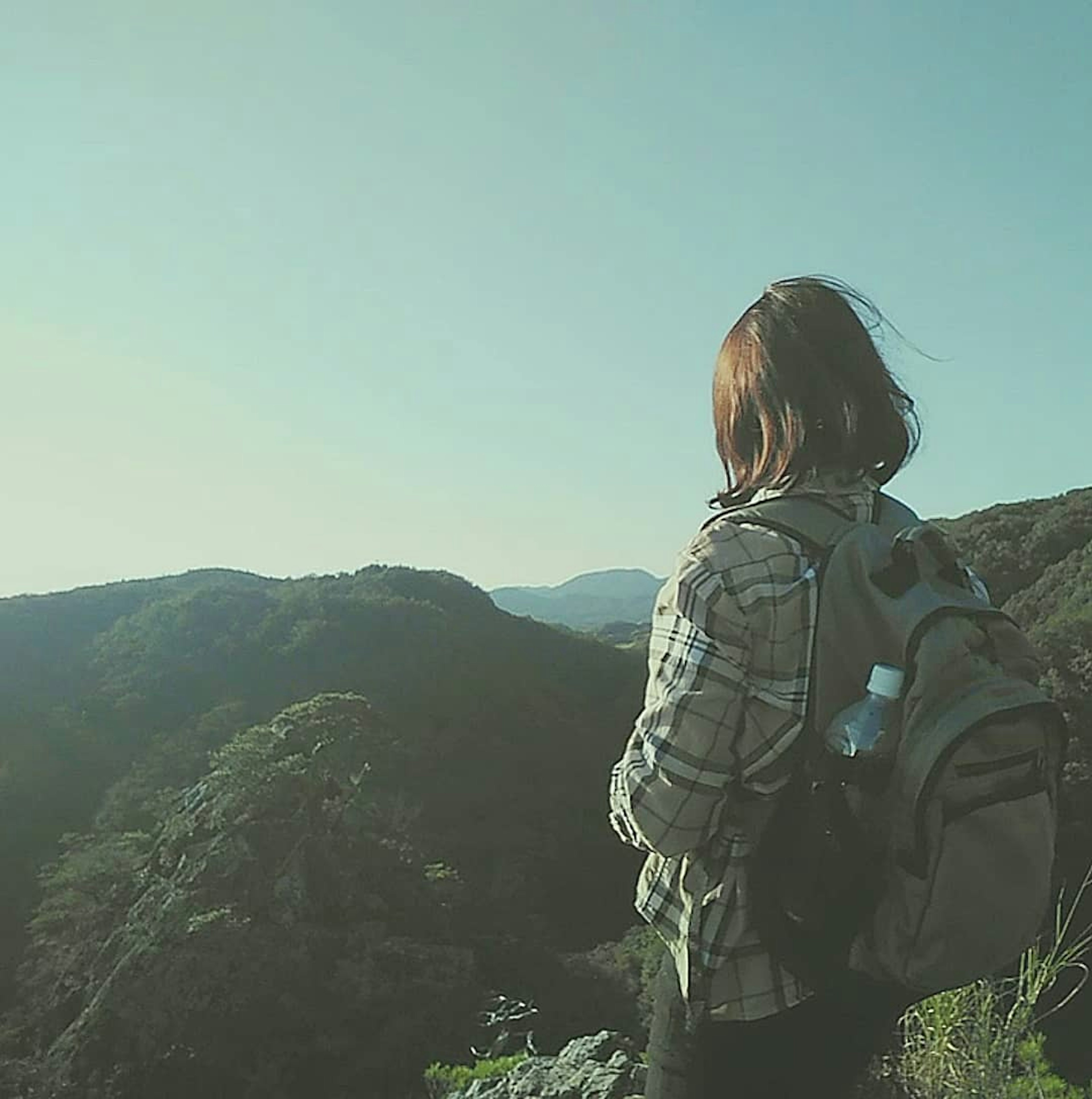 여성이 배낭을 메고 산을 바라보고 있다