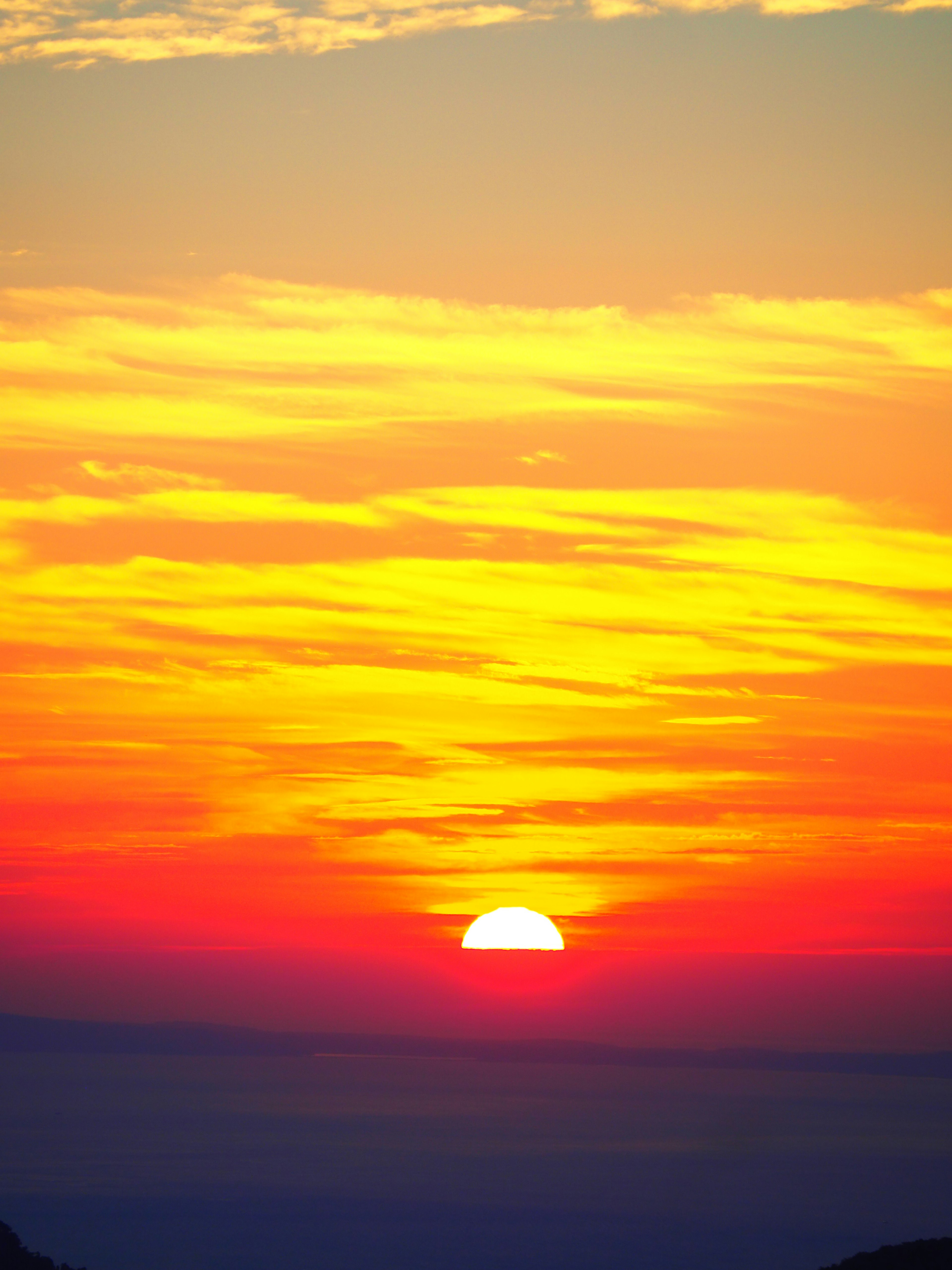 Un hermoso atardecer con tonos naranjas y amarillos en el cielo