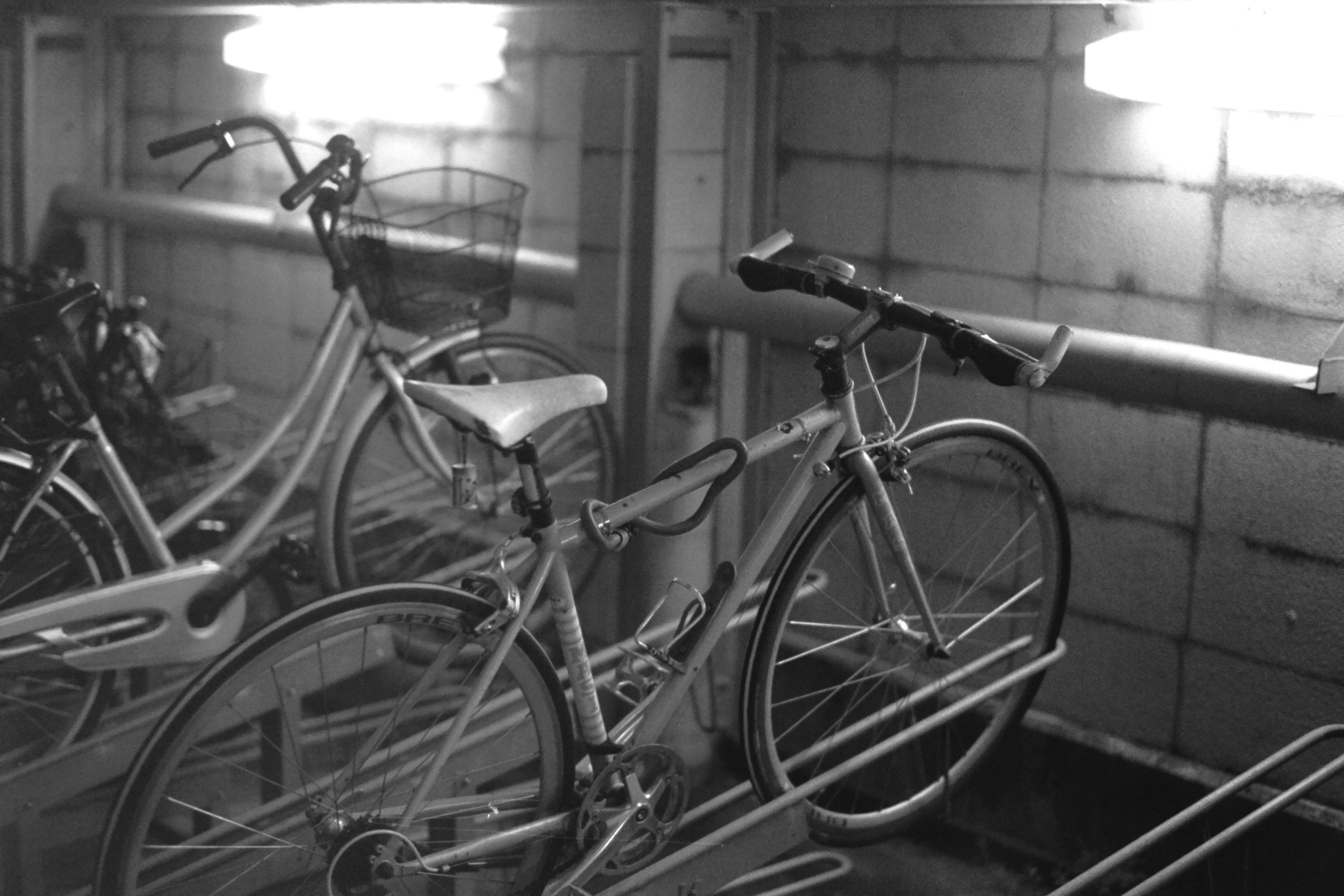 Black and white photo of bicycles on a rack with visible lighting