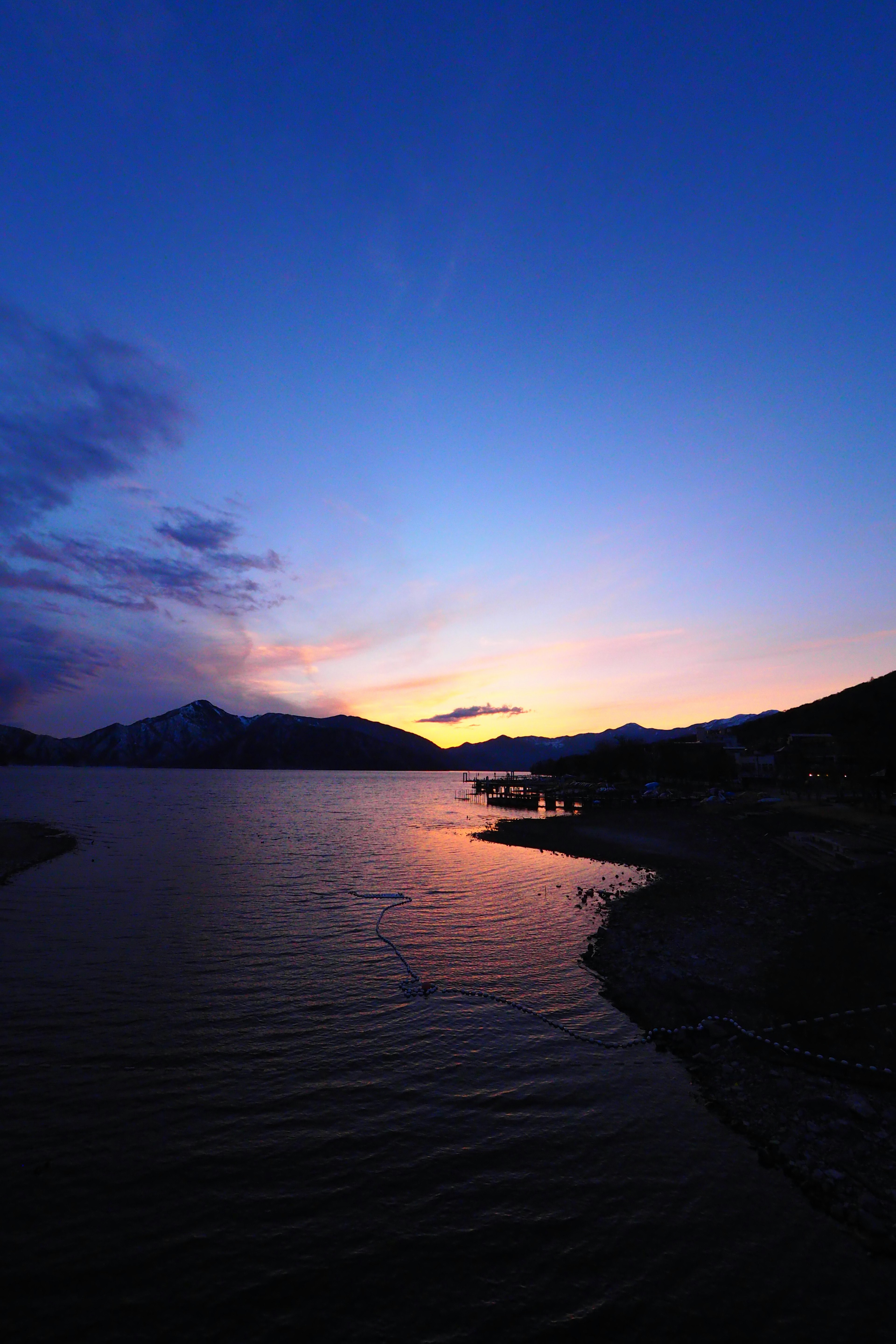 Twilight scene of a lake and mountains with colors reflected on the water