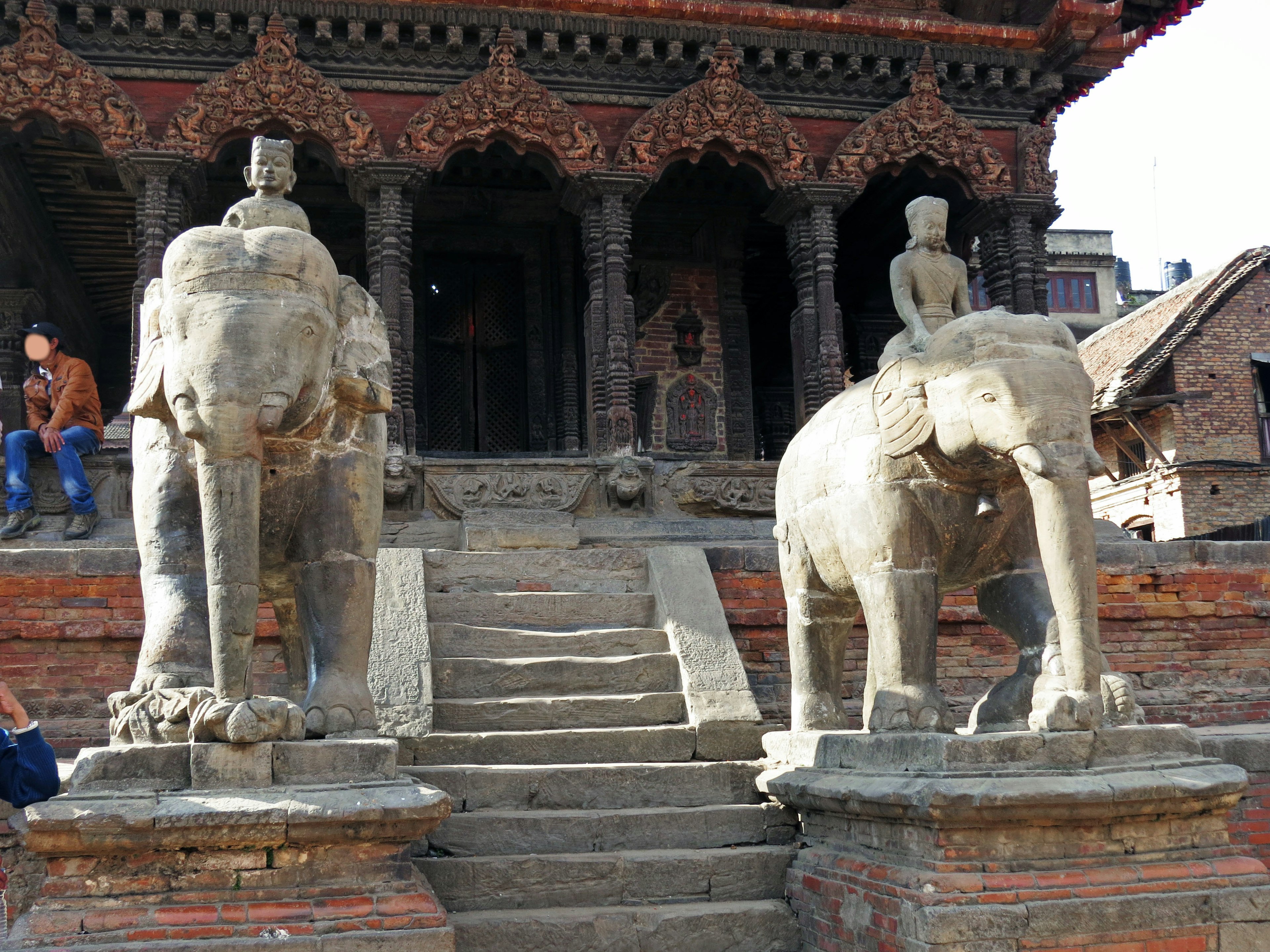 Zwei Steelefanten auf beiden Seiten einer Treppe vor einem alten Tempel