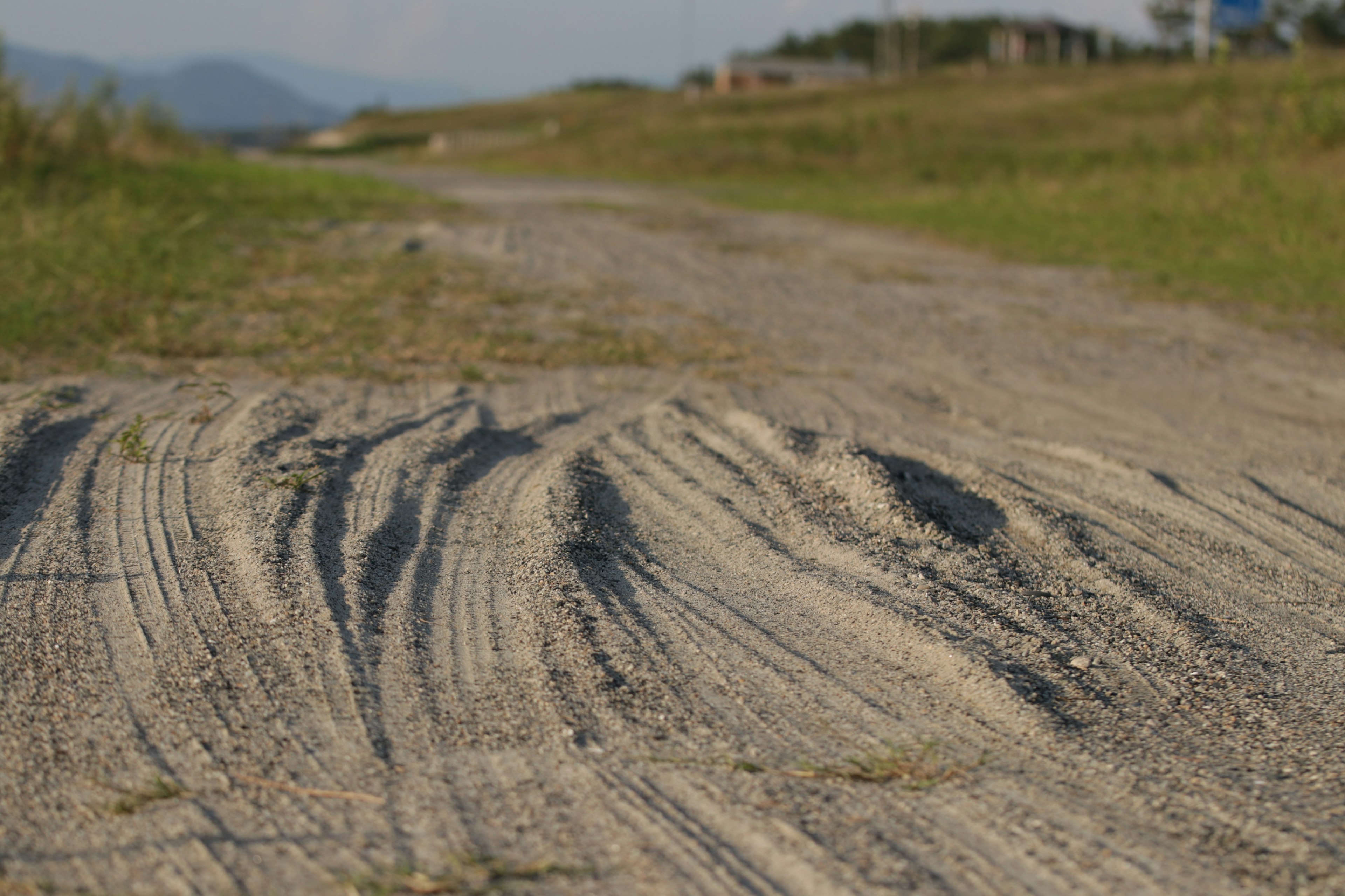 砂利道の車の轍が見える風景