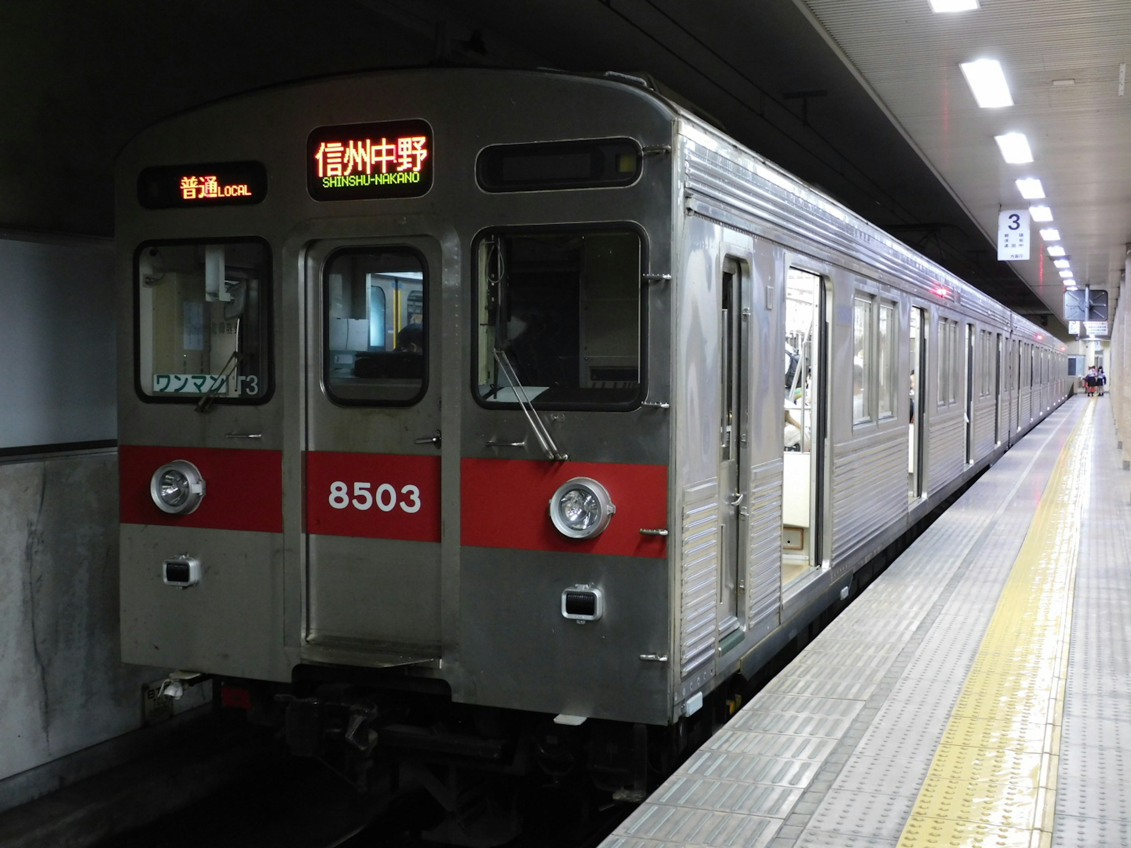 Tren de metro plateado detenido en la plataforma