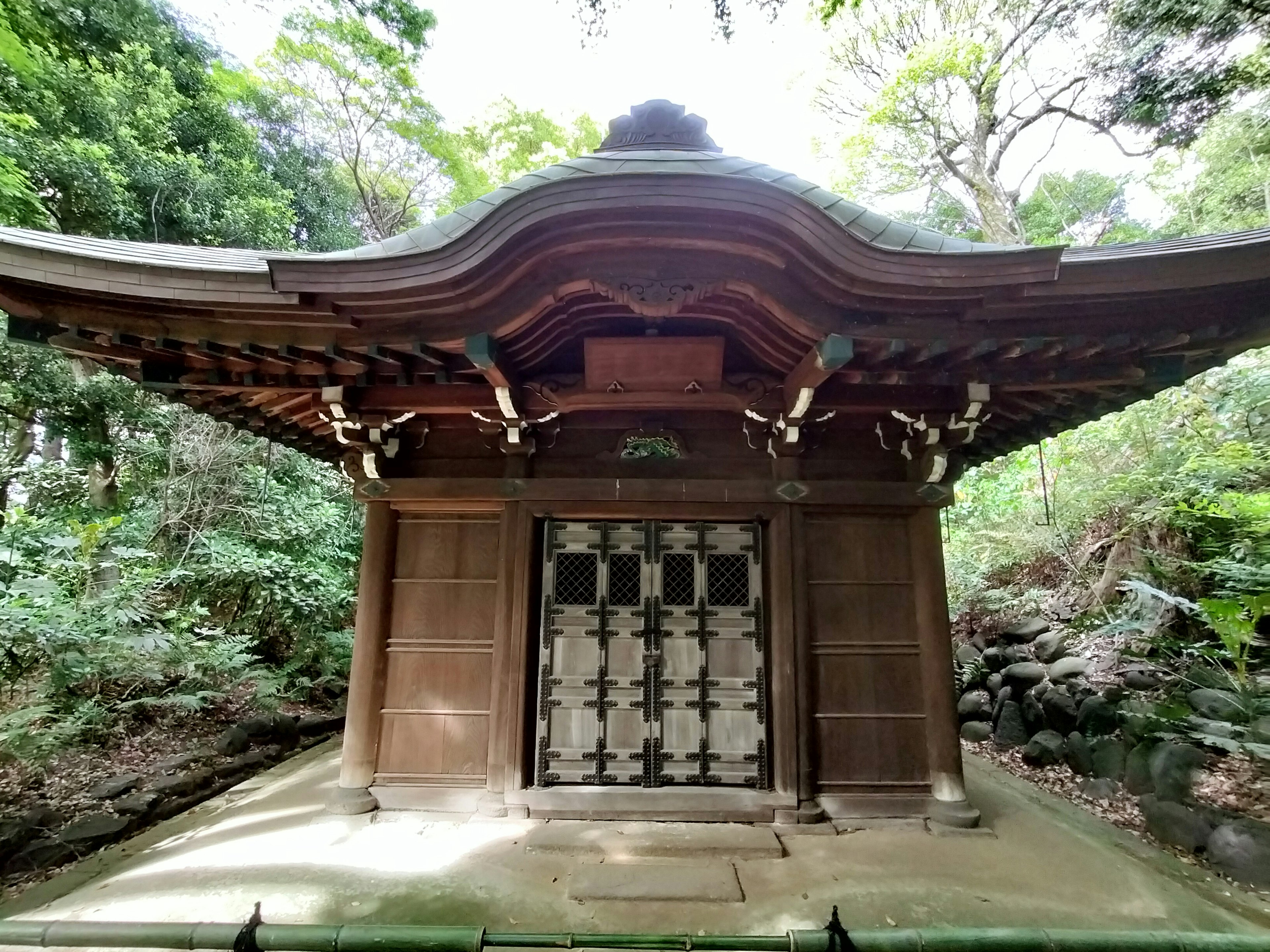 Bâtiment traditionnel de sanctuaire japonais entouré de verdure