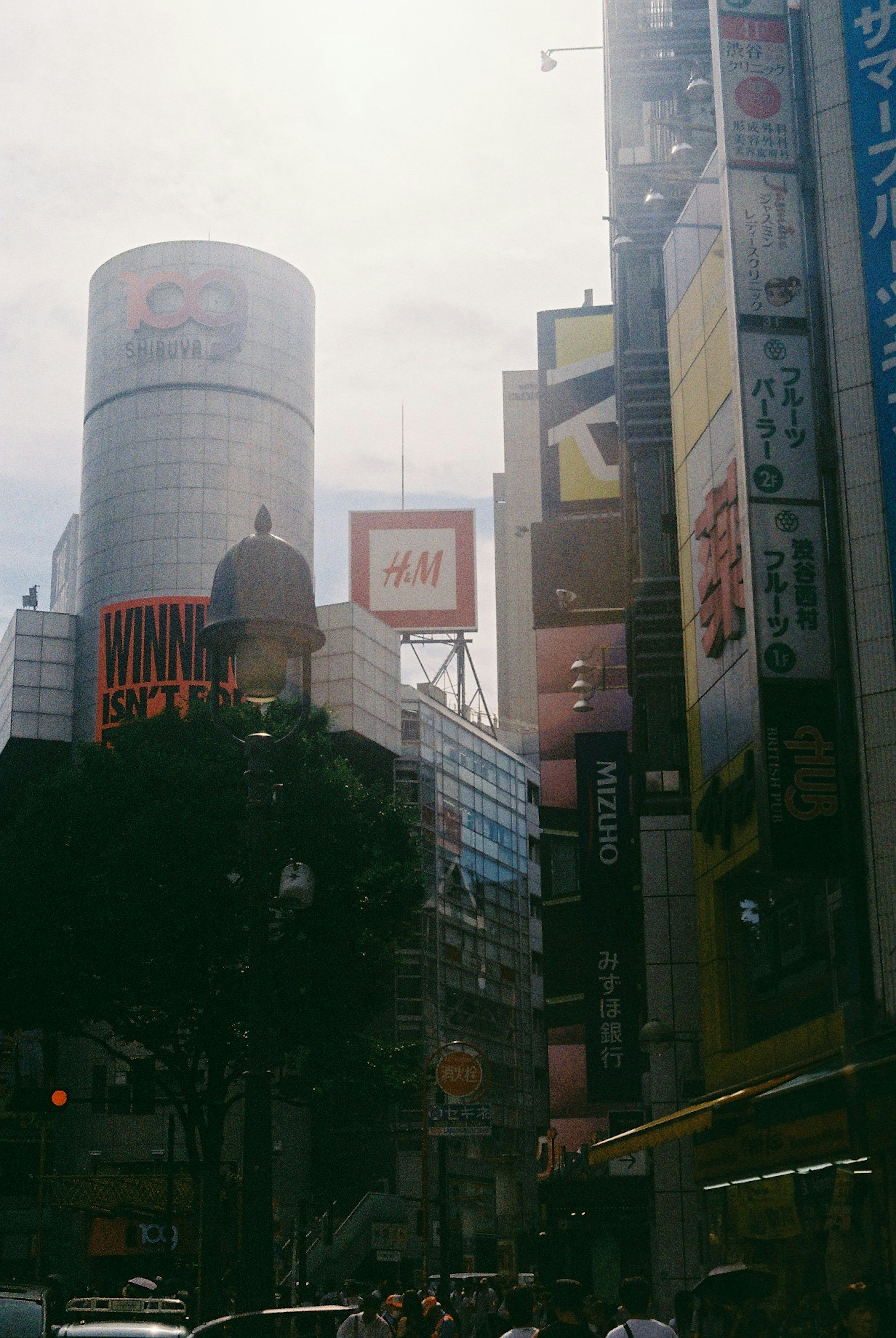 Belebte Straße in Shinjuku mit hohen Gebäuden und bunten Werbeanzeigen