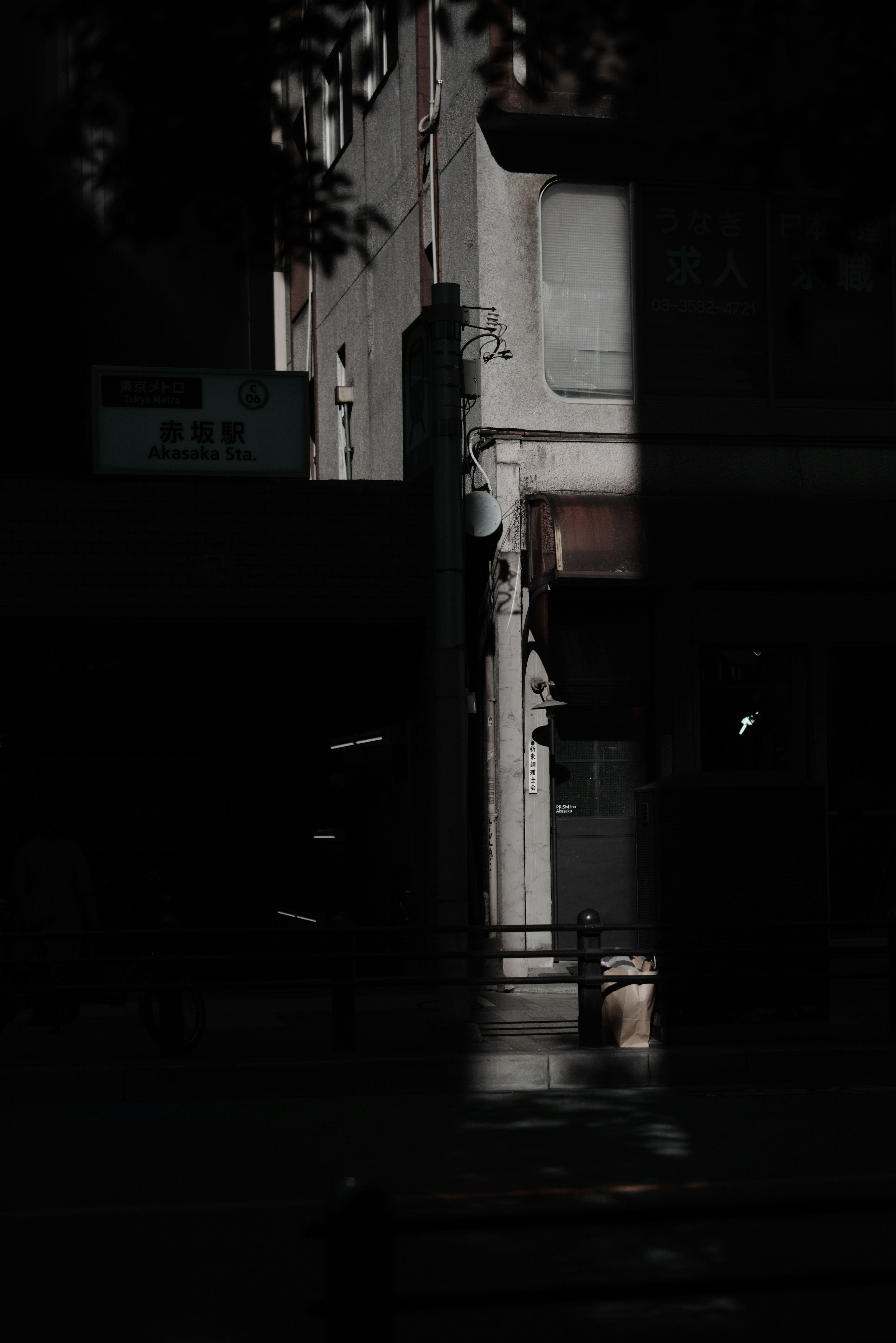 Partial view of a building on a dark street with shadows