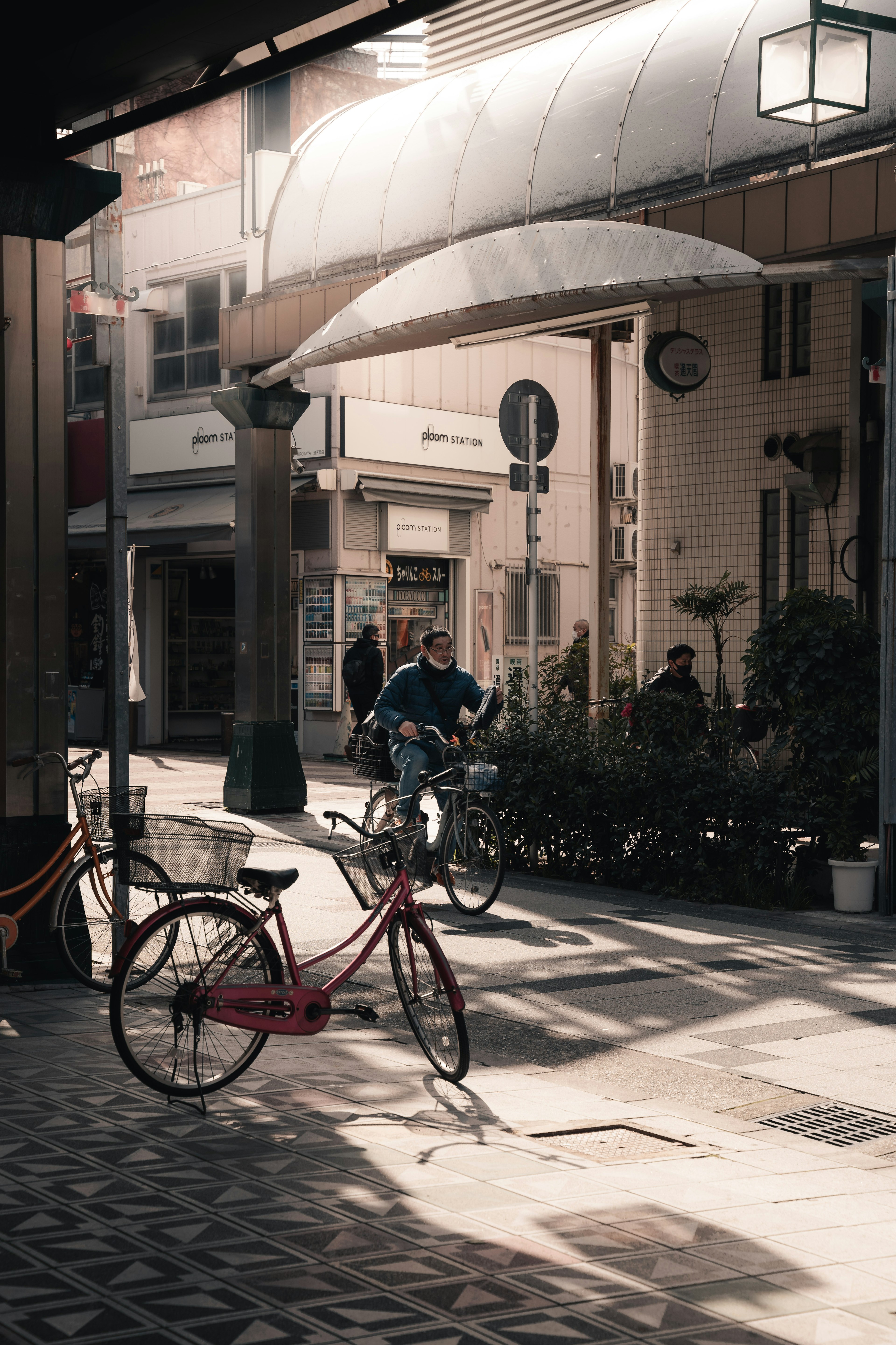 通りに自転車が置かれている風景 薄明かりの下で人々が行き交う