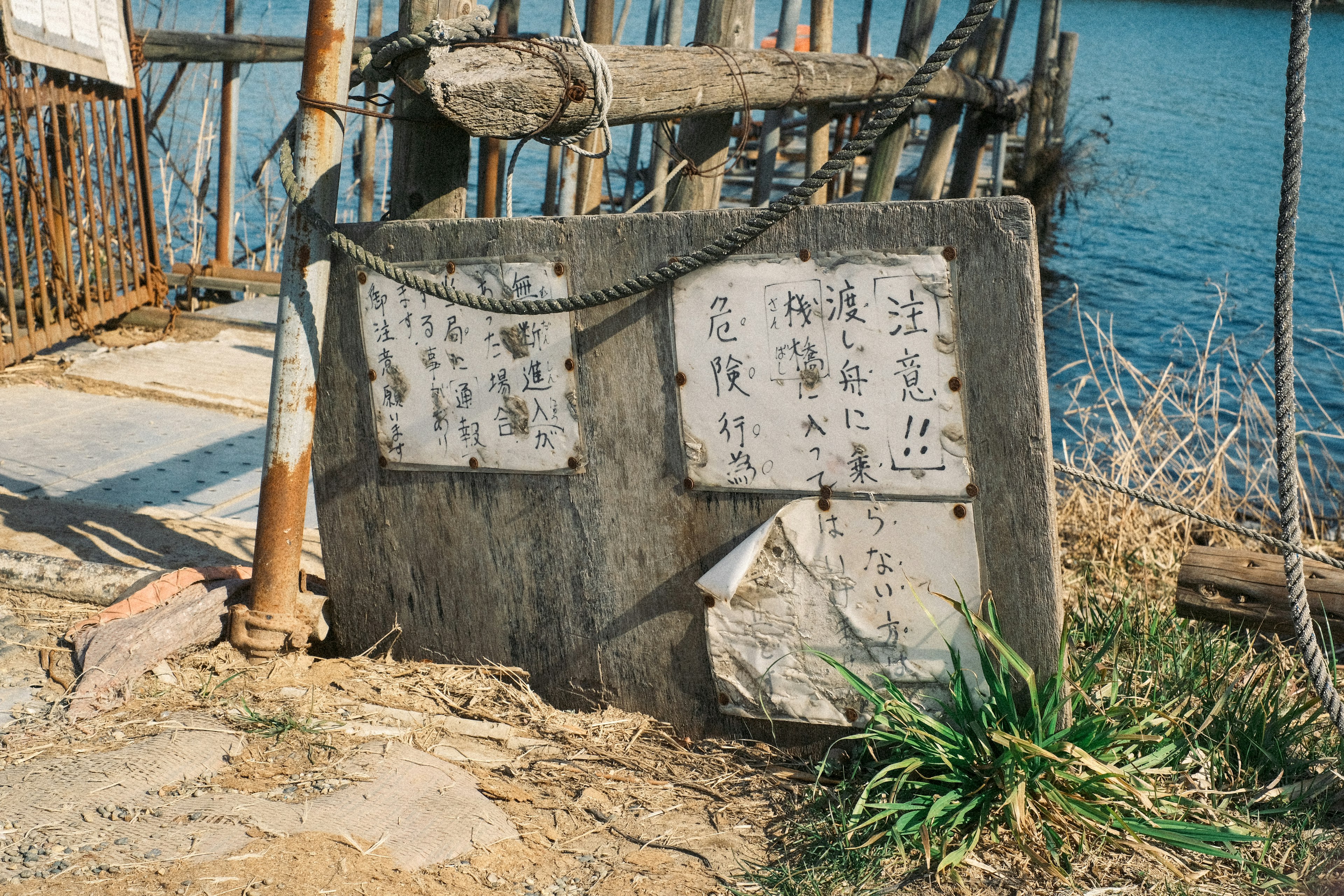 水辺にある古い石碑と草が生えた風景