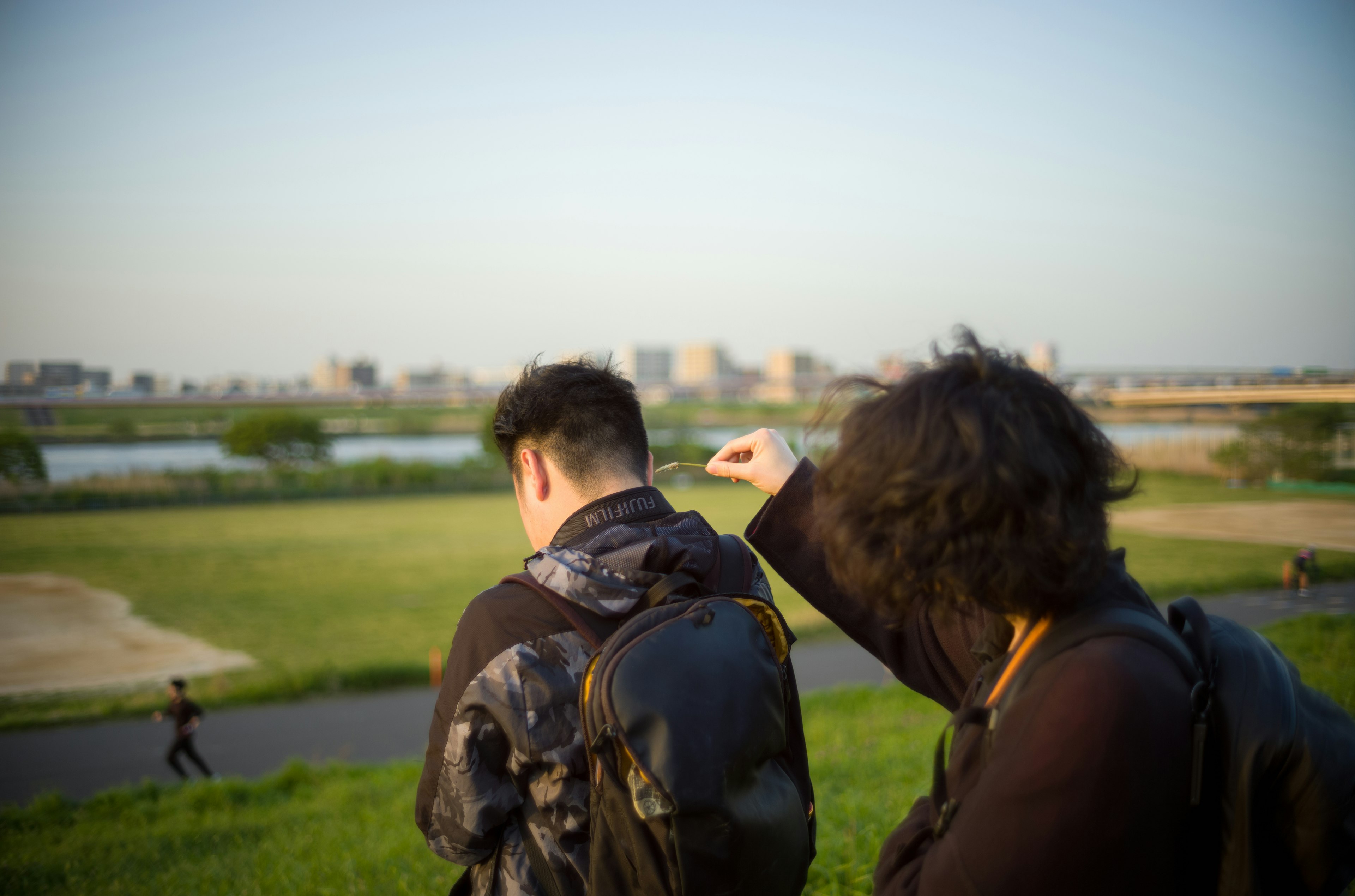 Vue arrière de jeunes au bord de la rivière avec un paysage urbain