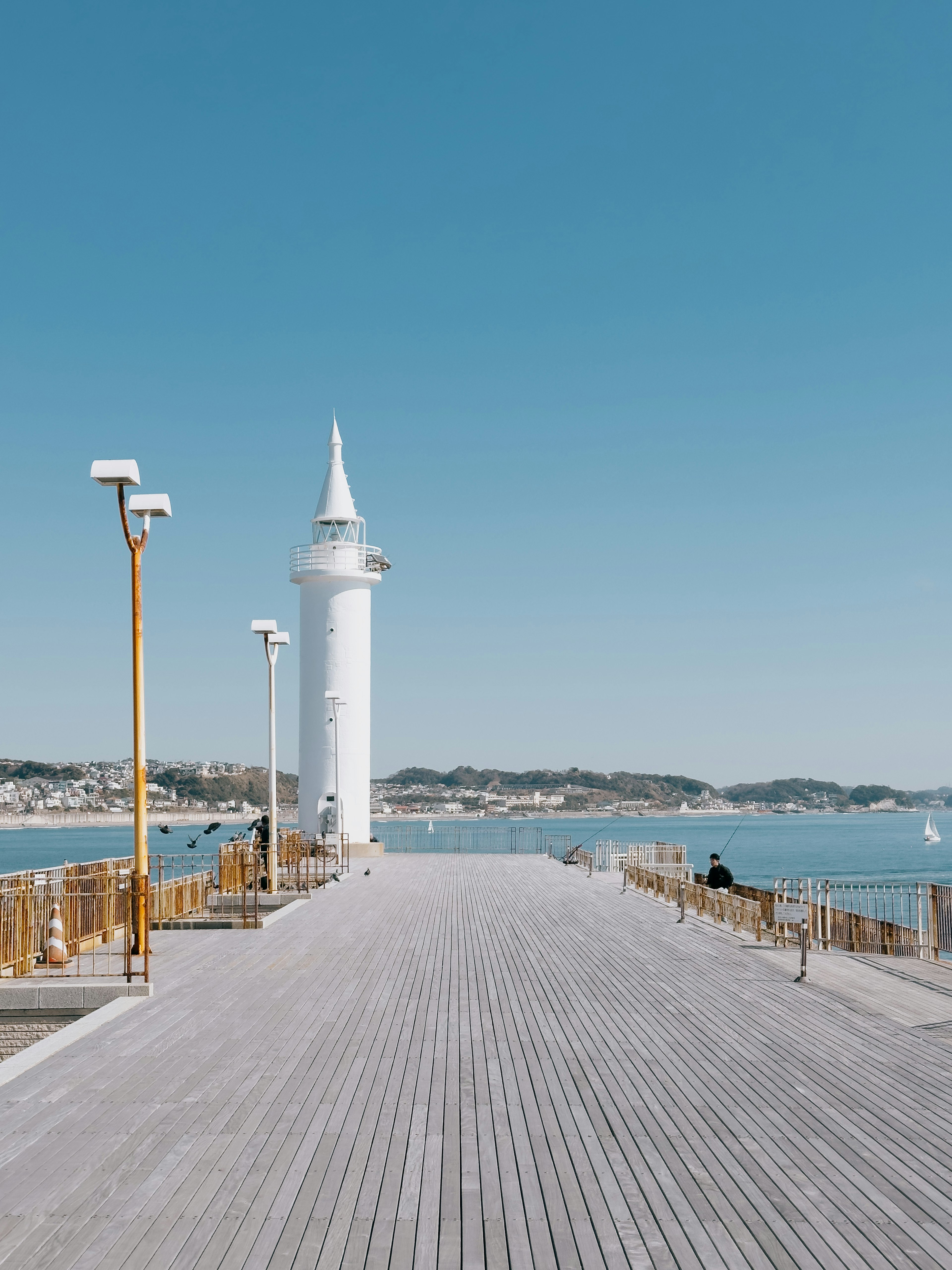 Vista escénica de un muelle con un faro blanco