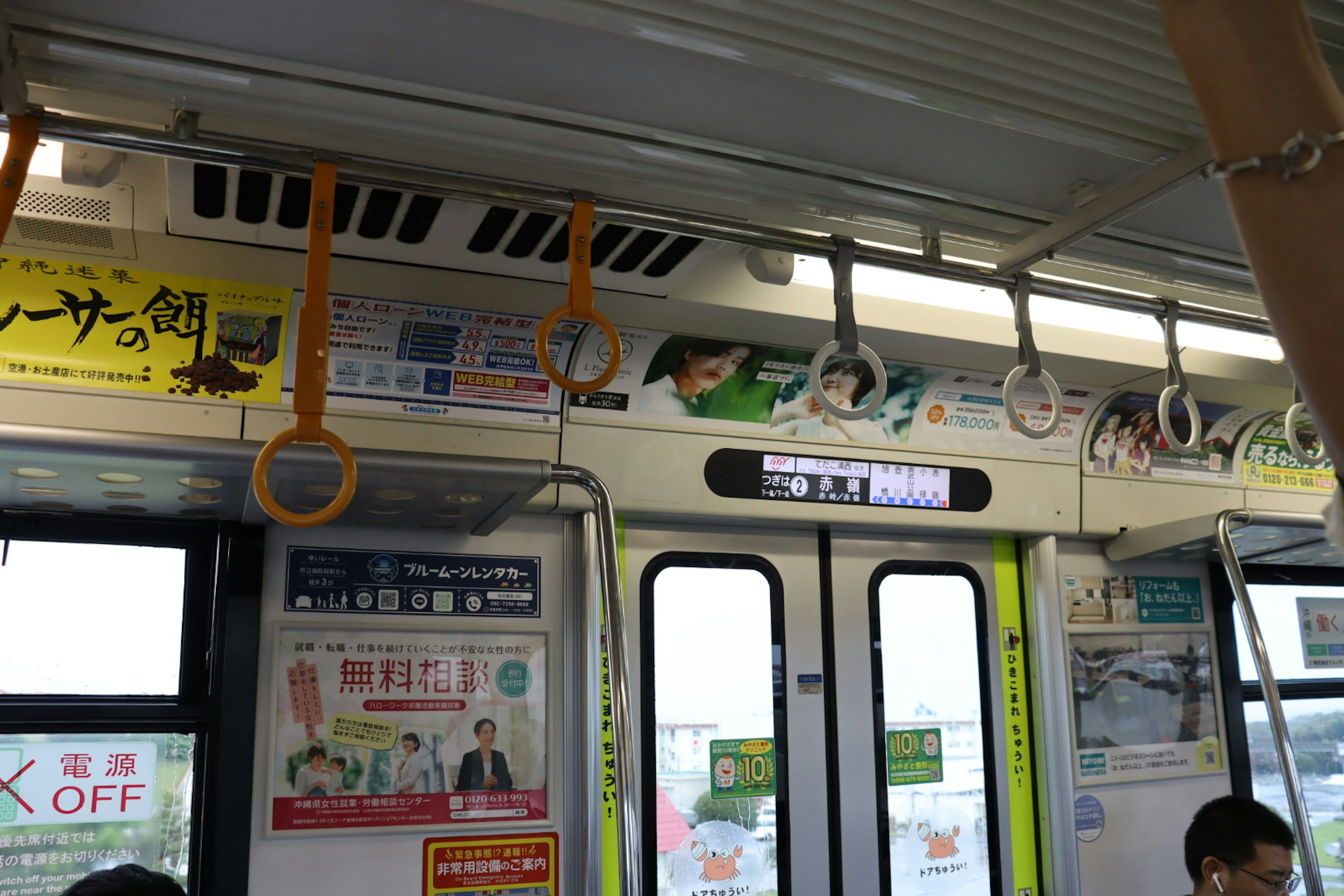 Intérieur d'un train avec des publicités et des poignées suspendues