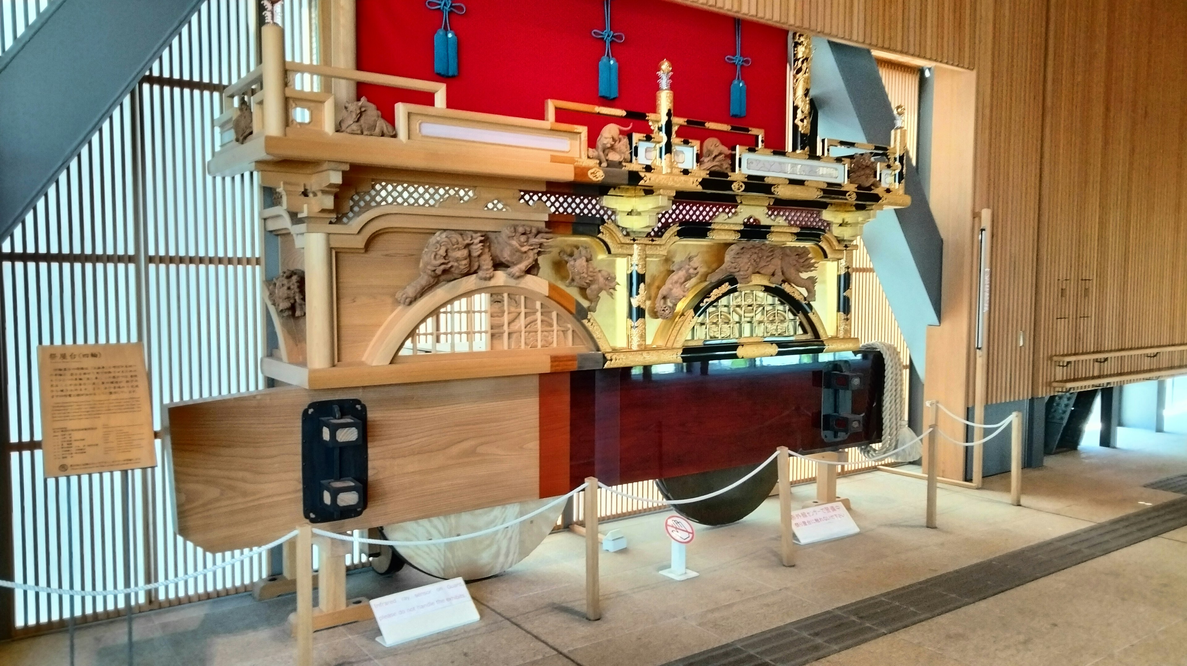 Exhibición de un instrumento musical japonés tradicional con estructura de madera ornamentada