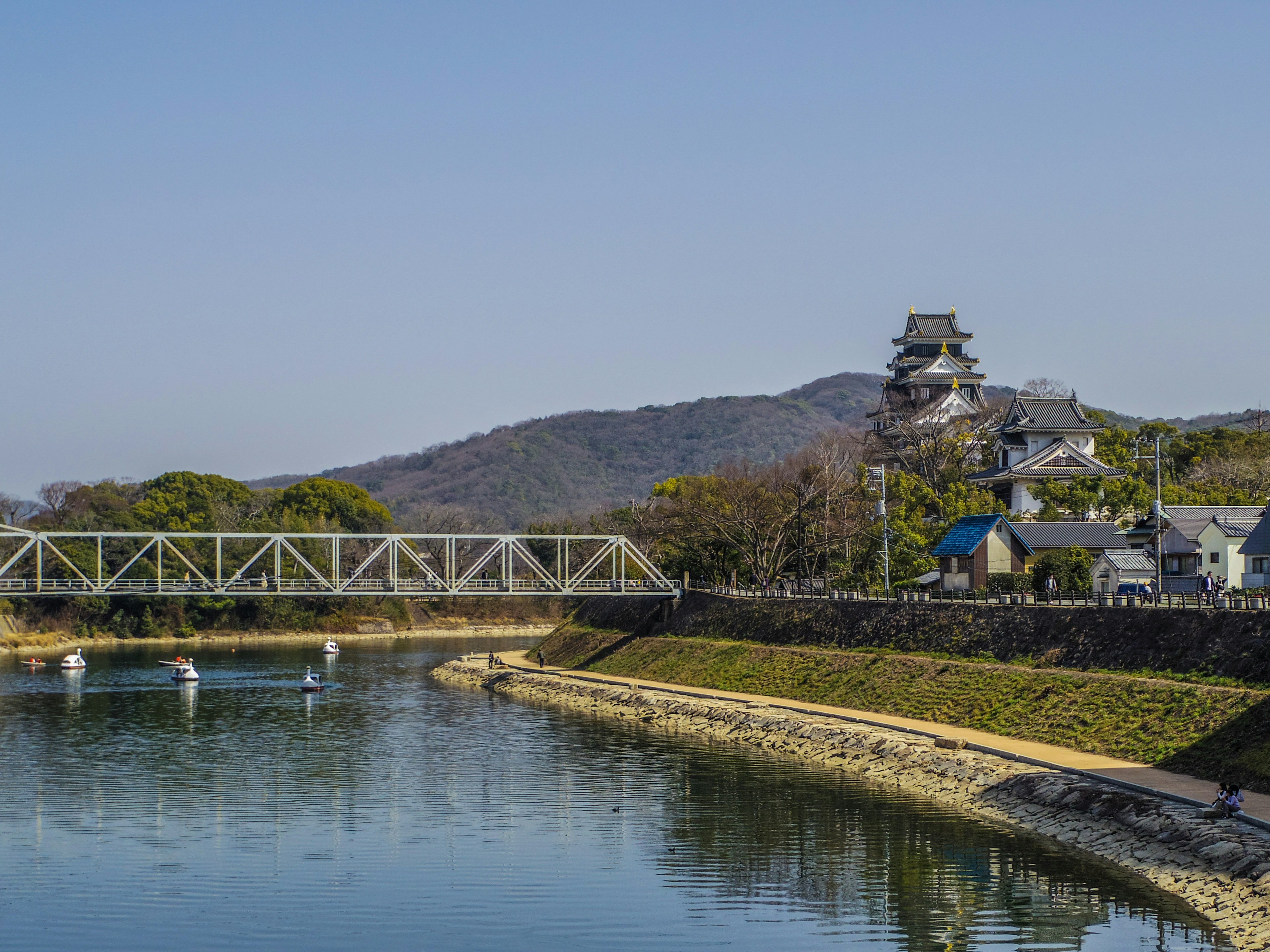 Vista escénica de un río con un puente y un castillo al fondo