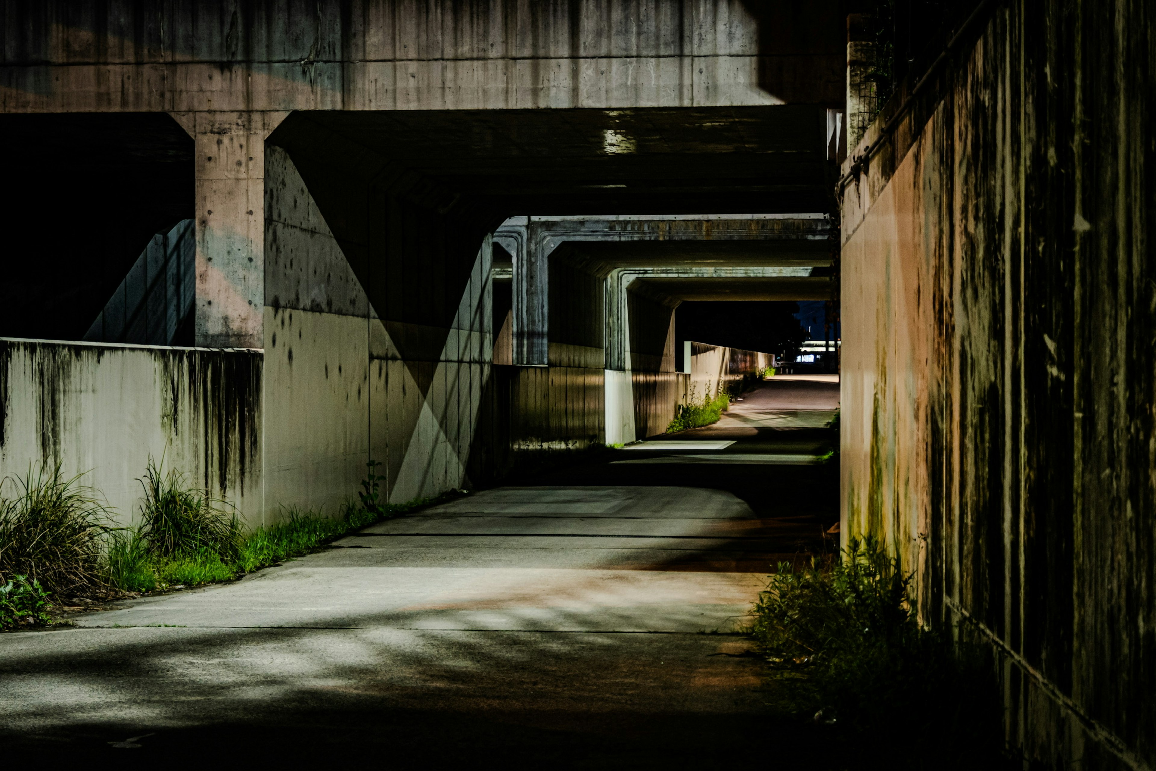 Sentiero scuro con strutture in cemento che somigliano a un tunnel