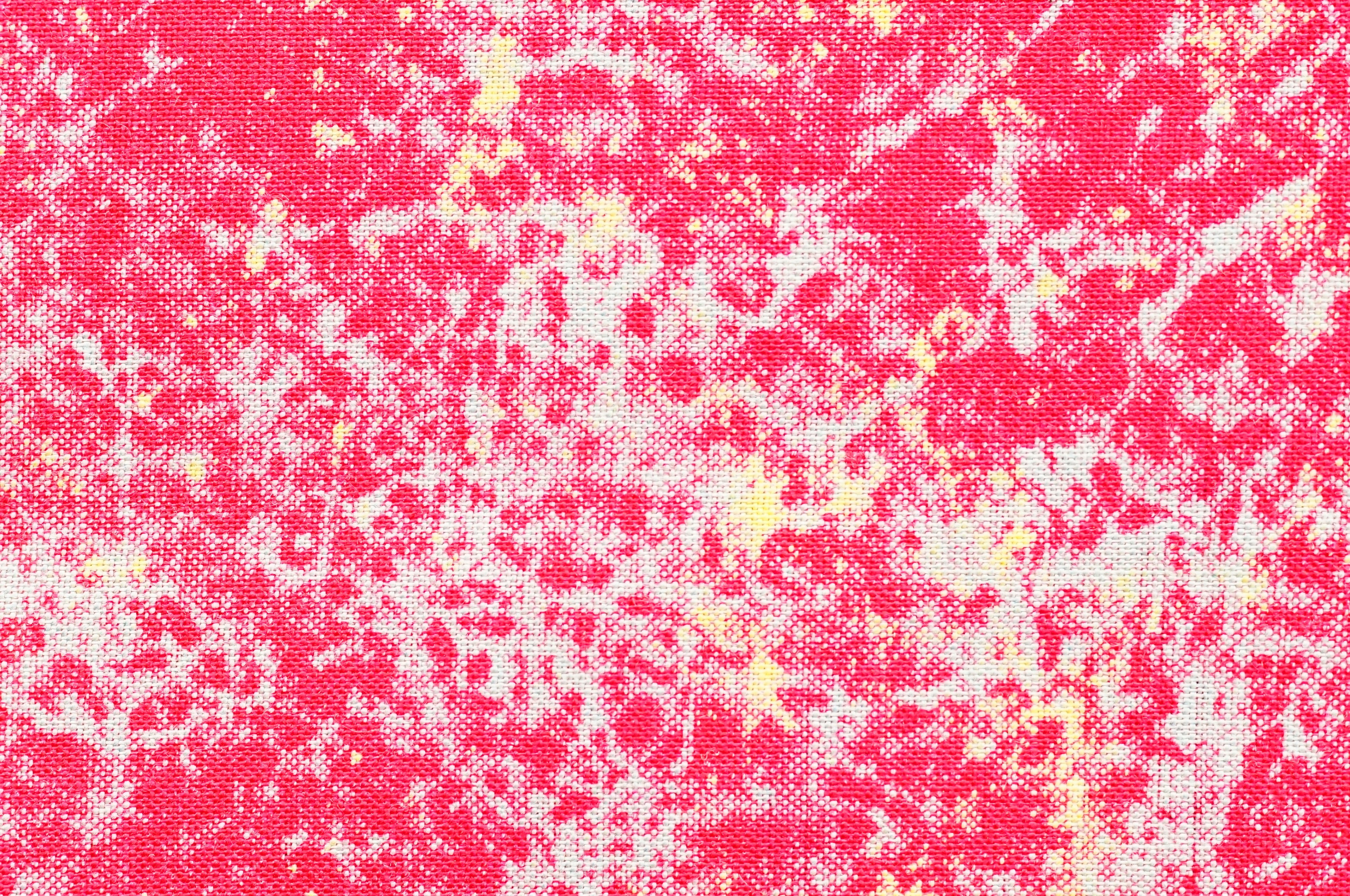 Texture rose vibrante avec des éclats blancs et jaunes créant un fond abstrait