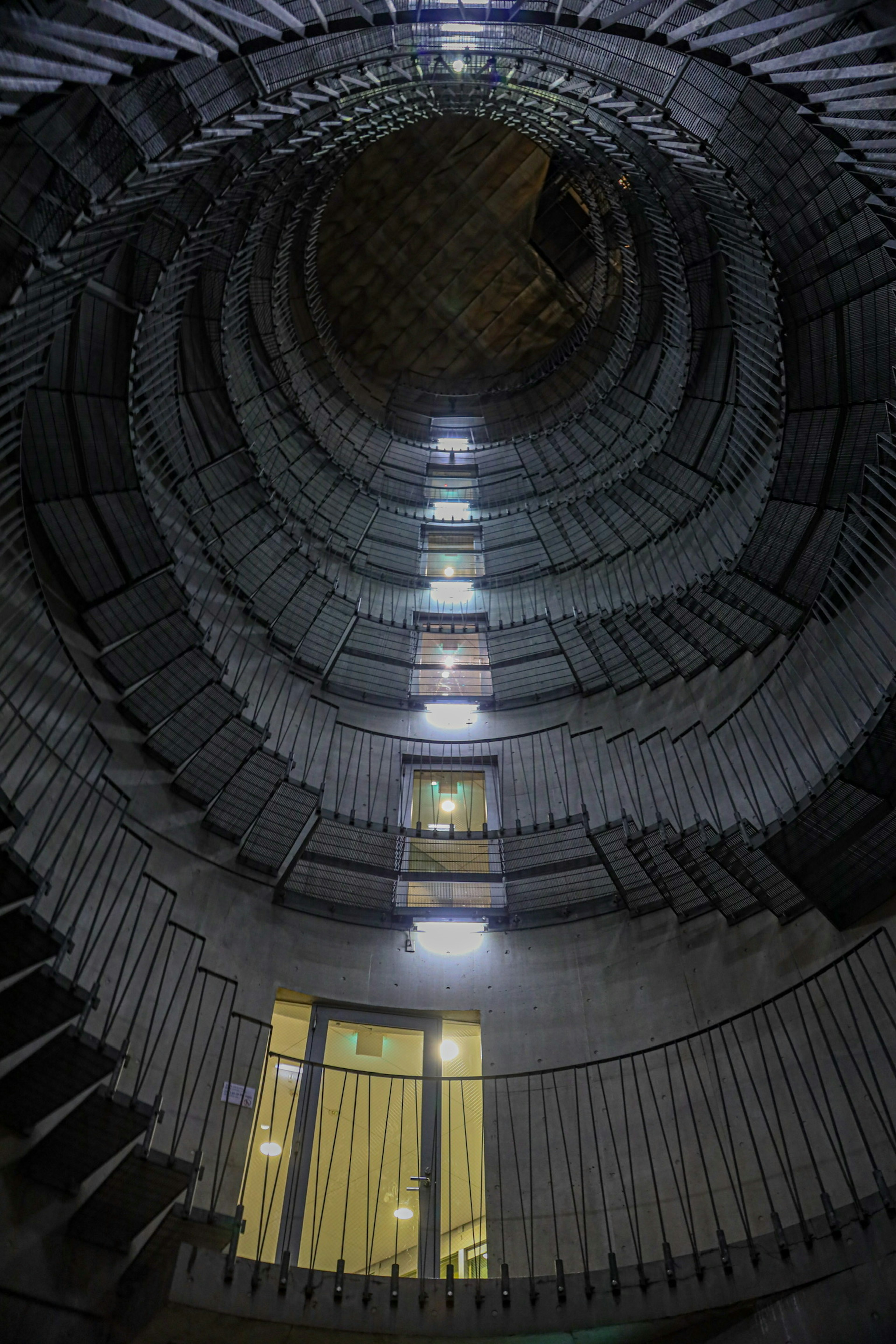 Innenansicht einer Wendeltreppe mit heller Beleuchtung, die die Stufen beleuchtet