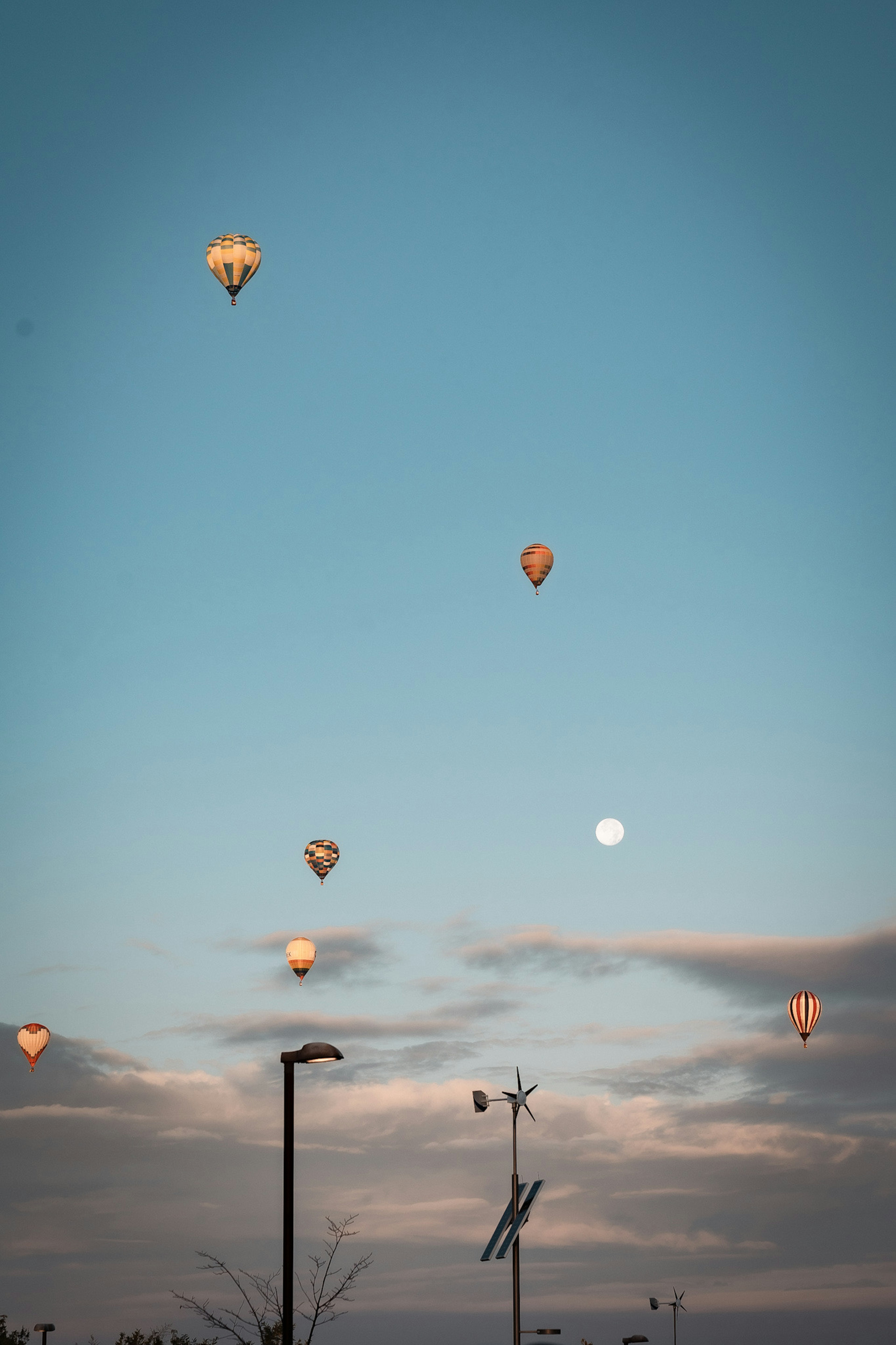 Palloni colorati nel cielo blu con una luna brillante