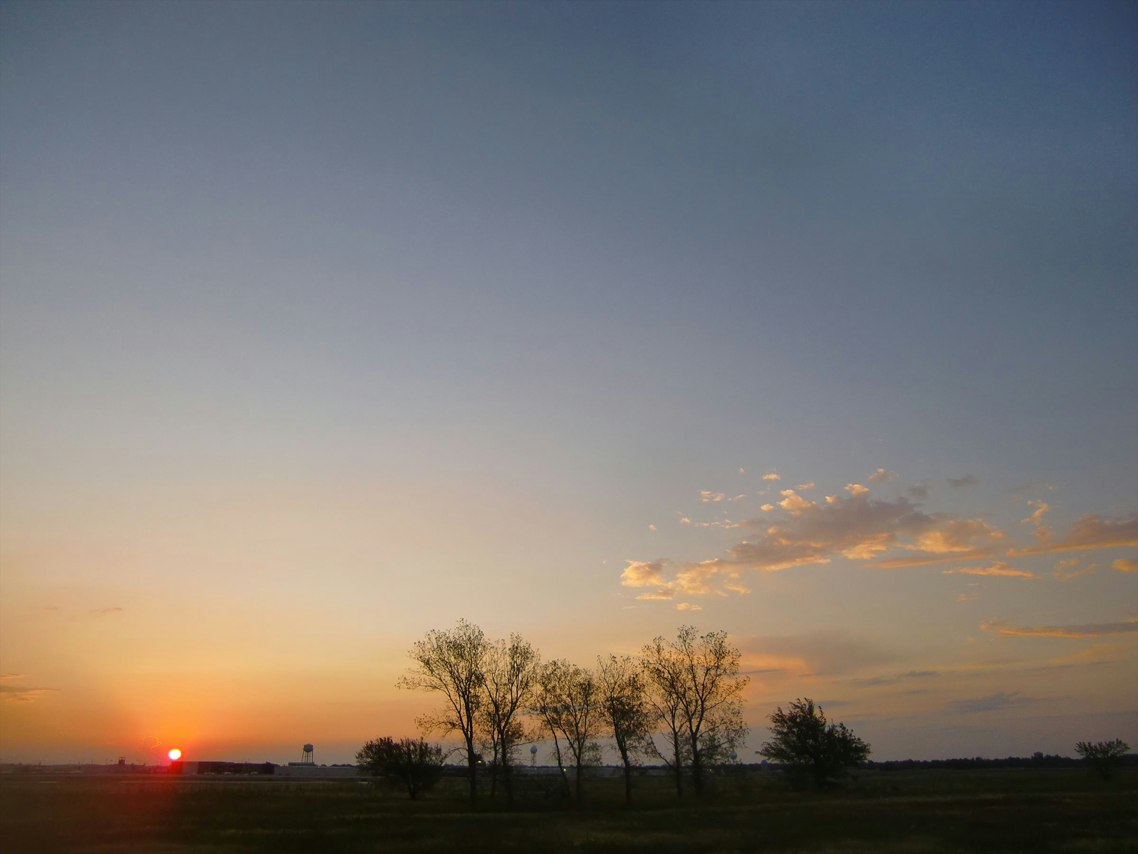 Malersiche Aussicht auf den Sonnenuntergang mit silhouettierten Bäumen vor einem bunten Himmel