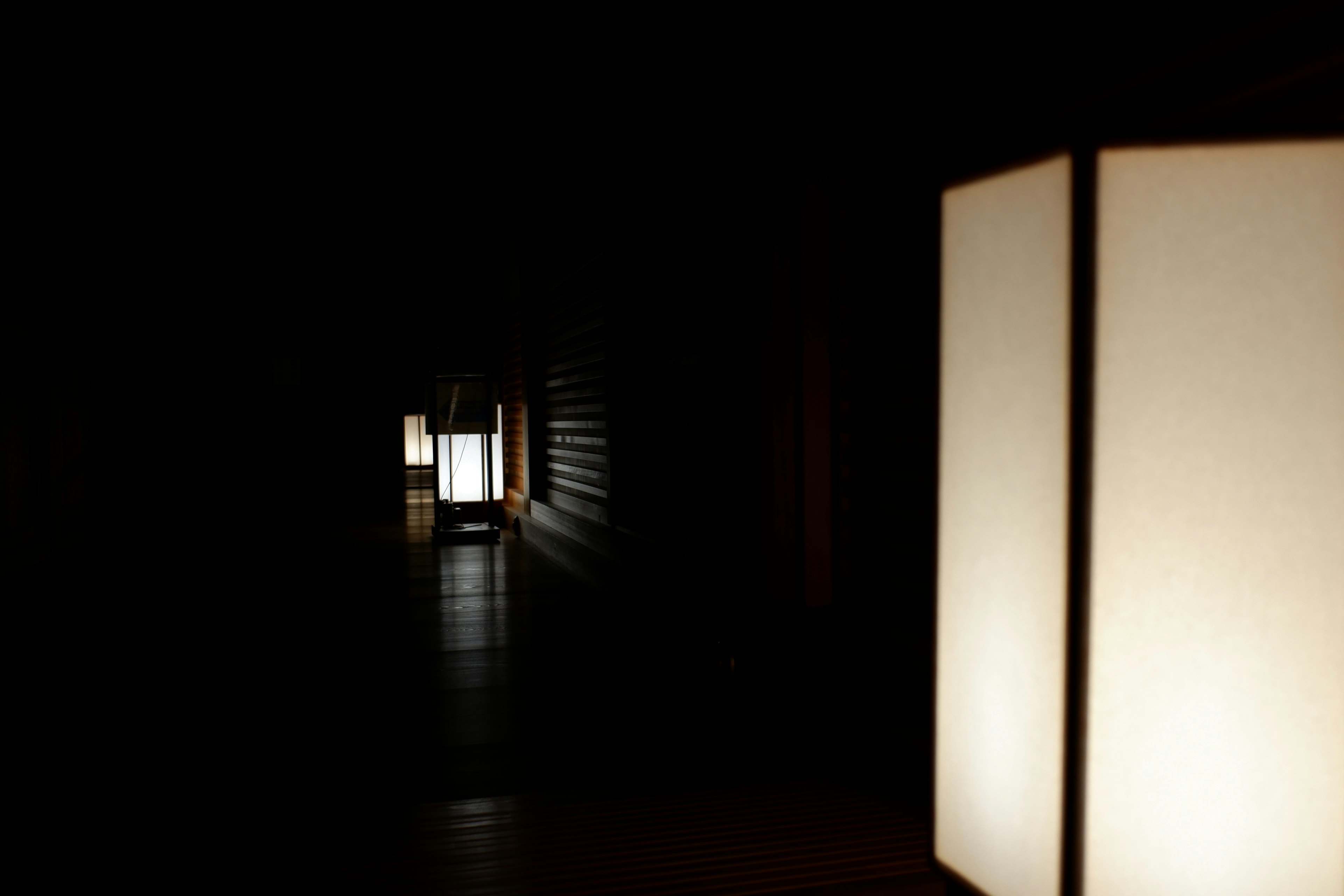 A dark corridor with white lanterns creating a serene atmosphere