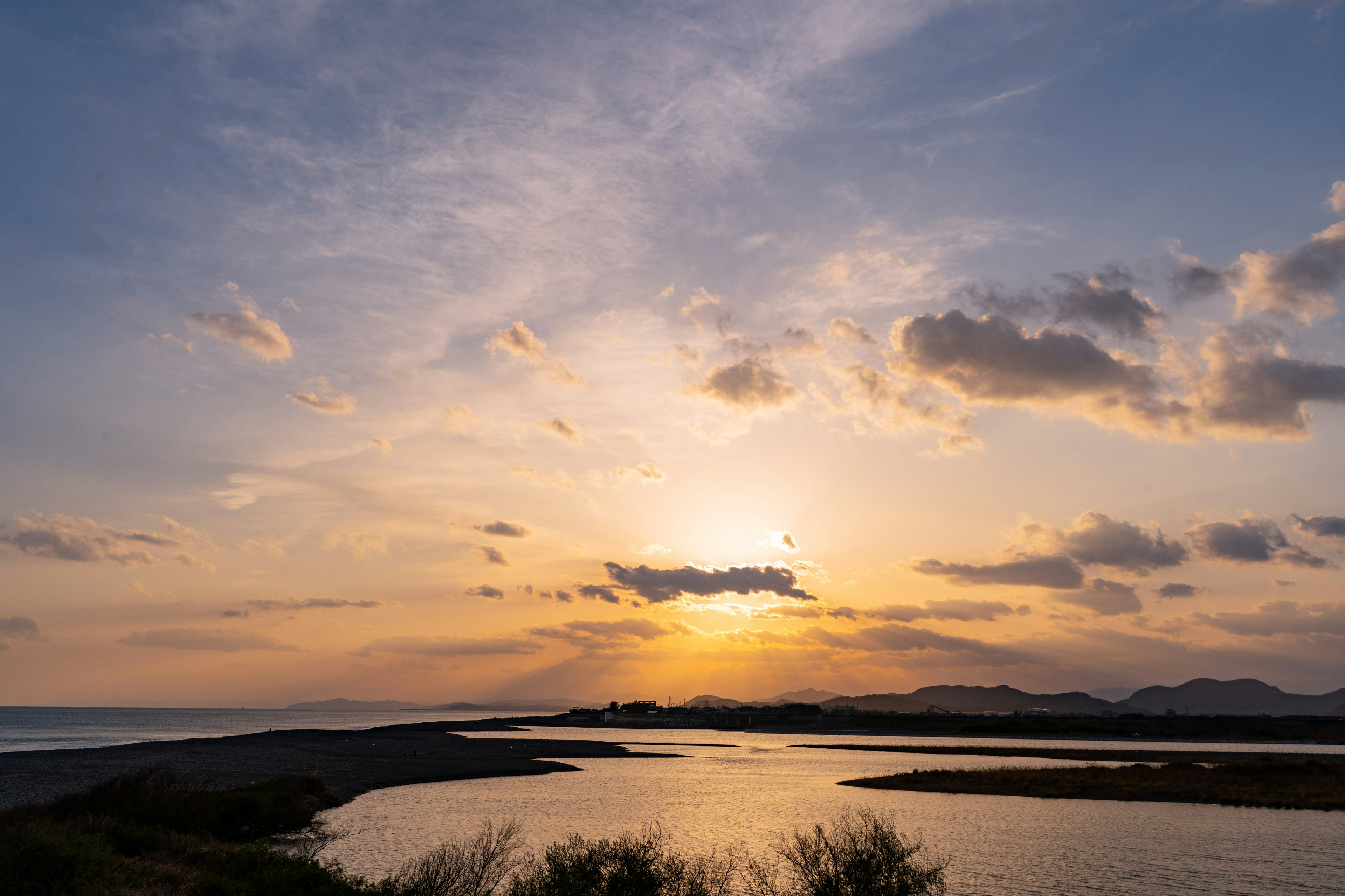 美しい夕日が海に沈む風景 濃いオレンジ色と青空のコントラスト