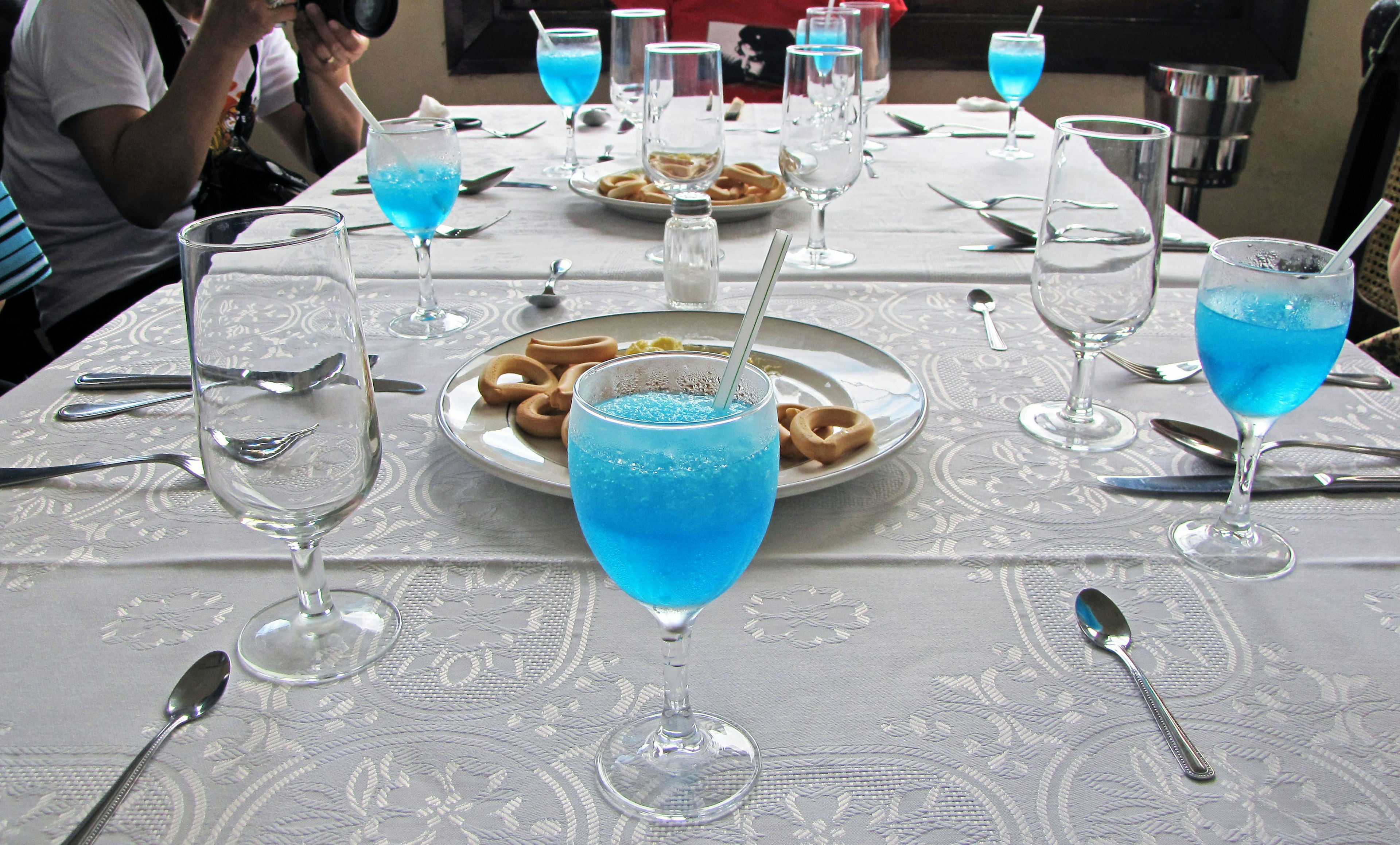 Table dressée avec des boissons bleues et une assiette de collations